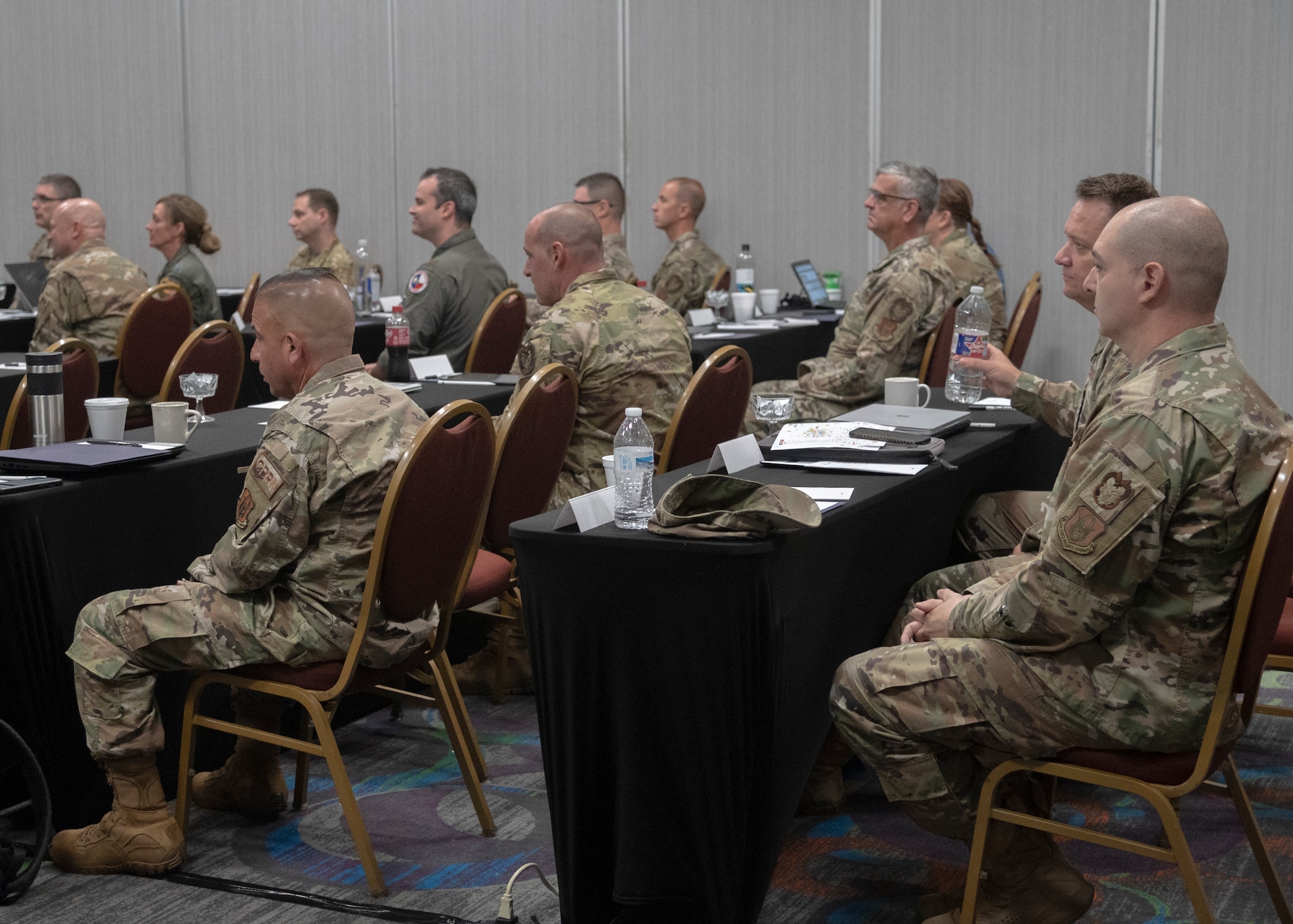 Commander points to paper while addressing 40 people in a room during Inspector General Inspection (IGI) teams across the Numbered Air Force during the first-ever 10th AF IGI conference