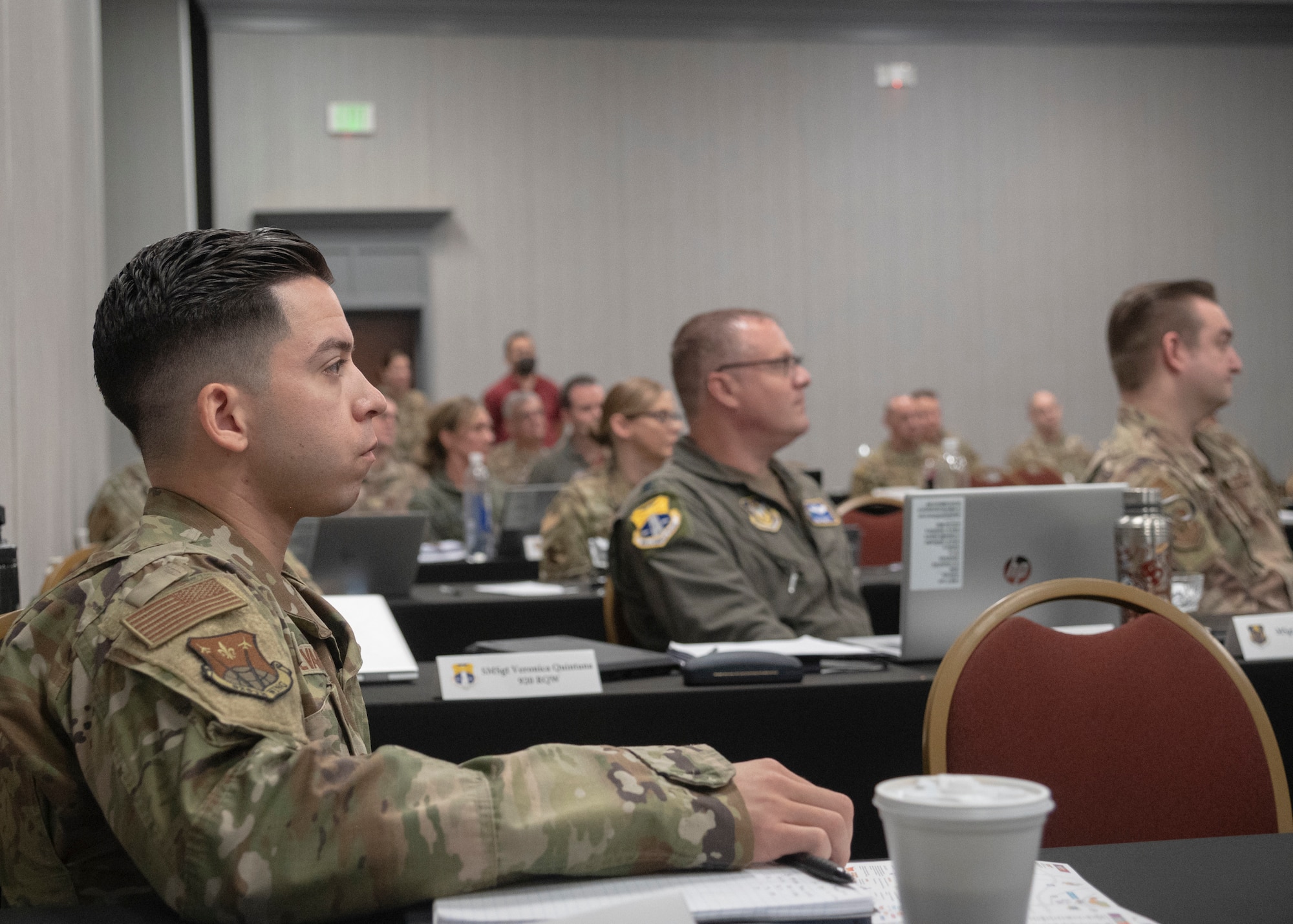Commander points to paper while addressing 40 people in a room during Inspector General Inspection (IGI) teams across the Numbered Air Force during the first-ever 10th AF IGI conference