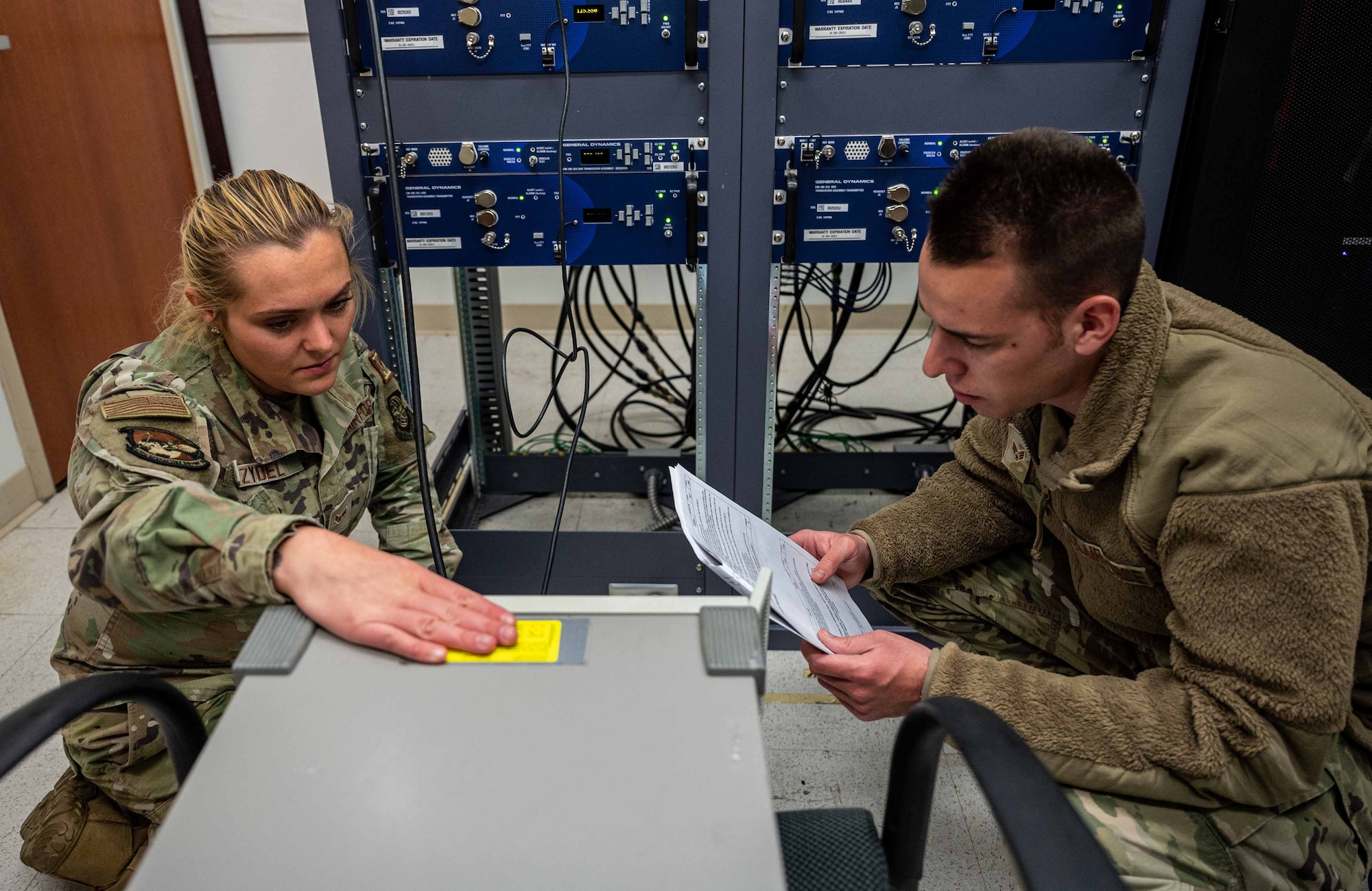 From the left, Airman 1st Class Alyssa Zydel and Senior Airman Albert Metz, both 436th Operation Support Squadron Radar Airfield and Weather System technician, tune an amplifier at Dover Air Force Base, Delaware, April 28, 2022. The RAWS team provides Team Dover with maintenance for over 200 airfield, air traffic control and weather operations navigational aids as well as the supporting equipment. (U.S. Air Force photo by Senior Airman Faith Schaefer)