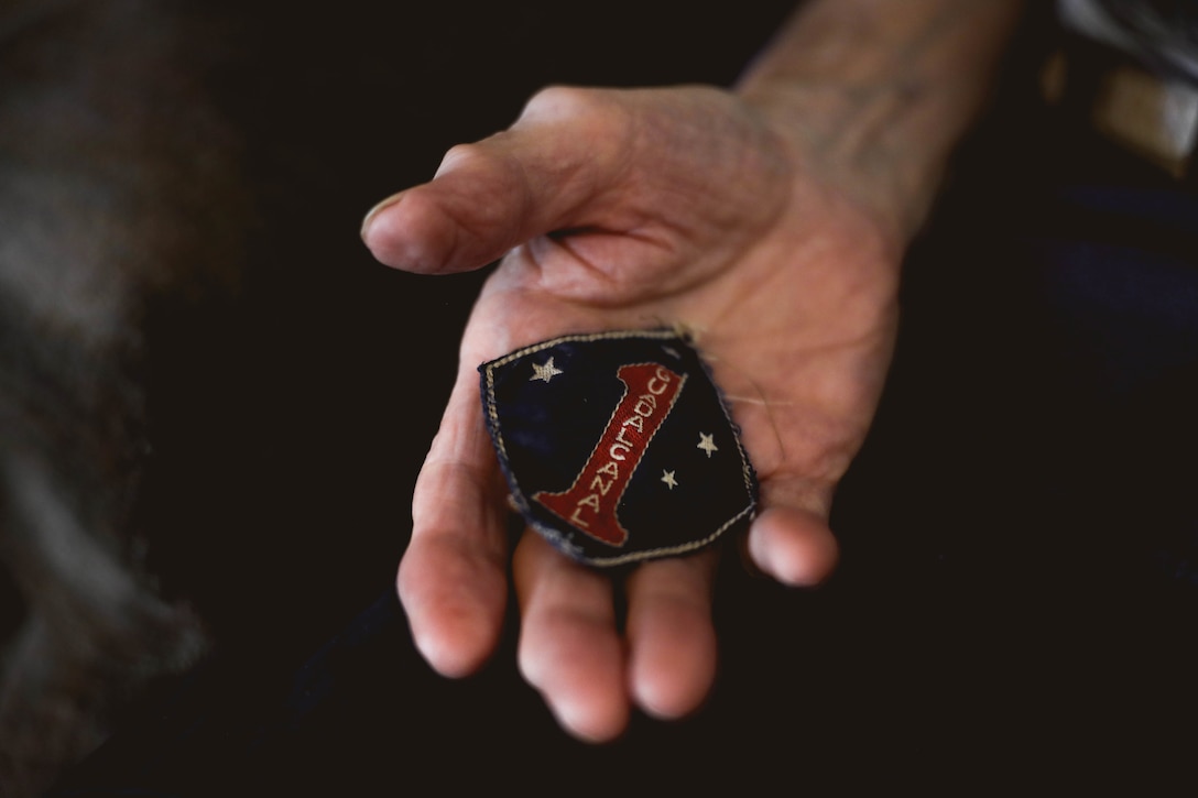 Richard Russell, a World War II Marine veteran, holds his 1st Marine Division shoulder patch during an interview at his home in Phoenix, July 23, 2022. Russell fought in the Battle of Guadalcanal during WWII, and turned 20 years old while fighting on the island. This year he will be celebrating his 100th birthday on the 80th anniversary of the battle.