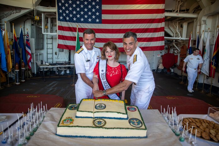 Rear Adm. Mark Sucato, left, Shellie Hart, middle, and Rear Adm. Carlos Sardiello cut a cake at the U.S. Navy reception held aboard Ticonderoga-class guided missile cruiser USS Lake Champlain (CG 57) during Fleet Week Seattle, Aug. 6, 2022.Fleet Week Seattle is a time-honored celebration of the sea services and provides an opportunity for the citizens of Washington to meet Sailors, Marines and Coast Guardsmen, as well as witness firsthand the latest capabilities of today's maritime services. (U.S. Navy Photo by Mass Communication Specialist 2nd Class Ethan J. Soto)