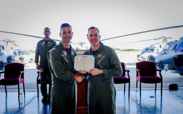 Two officers posing for a photo while holding an award certificate