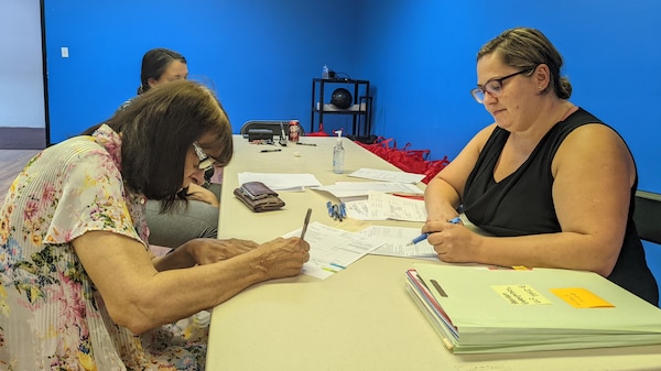 Attorney Sanja Bogdanovic (Right) and Notary Cindy Clark (Background) assist Sandra Engle, resident of Loyall, Kentucky, with processing an easement at Loyall City Hall July 21, 2022. This is the first easement closing that took place for the Loyall Flow-Through Ponding Project. (USACE Photo)