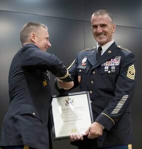Lt. Col. Mark Lueken, who serves as the deputy G-6 during drill status duty, presents Illinois Army National Guard 1st Sgt. Ryan Crews of Mount Vernon, Illinois, a certificate of retirement during the retirement ceremony Aug. 7 at the Illinois Military Academy, Camp Lincoln, Springfield.
