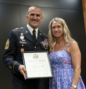 Illinois Army National Guard 1st Sgt. Ryan Crews, of Mount Vernon, presents a certificate of appreciation to wife, Sara, during a retirement ceremony Aug. 7 at the Illinois Military Academy, Camp Lincoln, Springfield, Illinois.