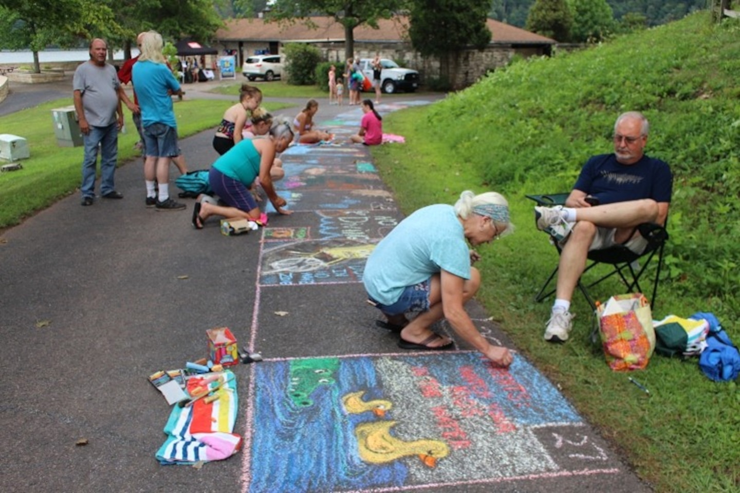 People are writing with chalk on the sidewalk
