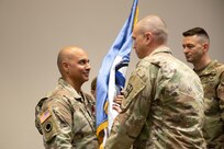 Col. Shahram Takmili receives the organizational colors from Command Sgt. Maj. Samuel Turville