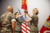 U.S. Navy Cmdr. Autumn Riddell, incoming company commander, receives the company colors from Lt. Cmdr. Jennifer Simmons, outgoing commander, during the Bravo Surgical Company, 3d Medical Battalion change of command, Aug. 1, 2022. Simmons relinquished command to Riddell. (U.S. Marine Corps photo by Cpl. Samantha Sanchez)