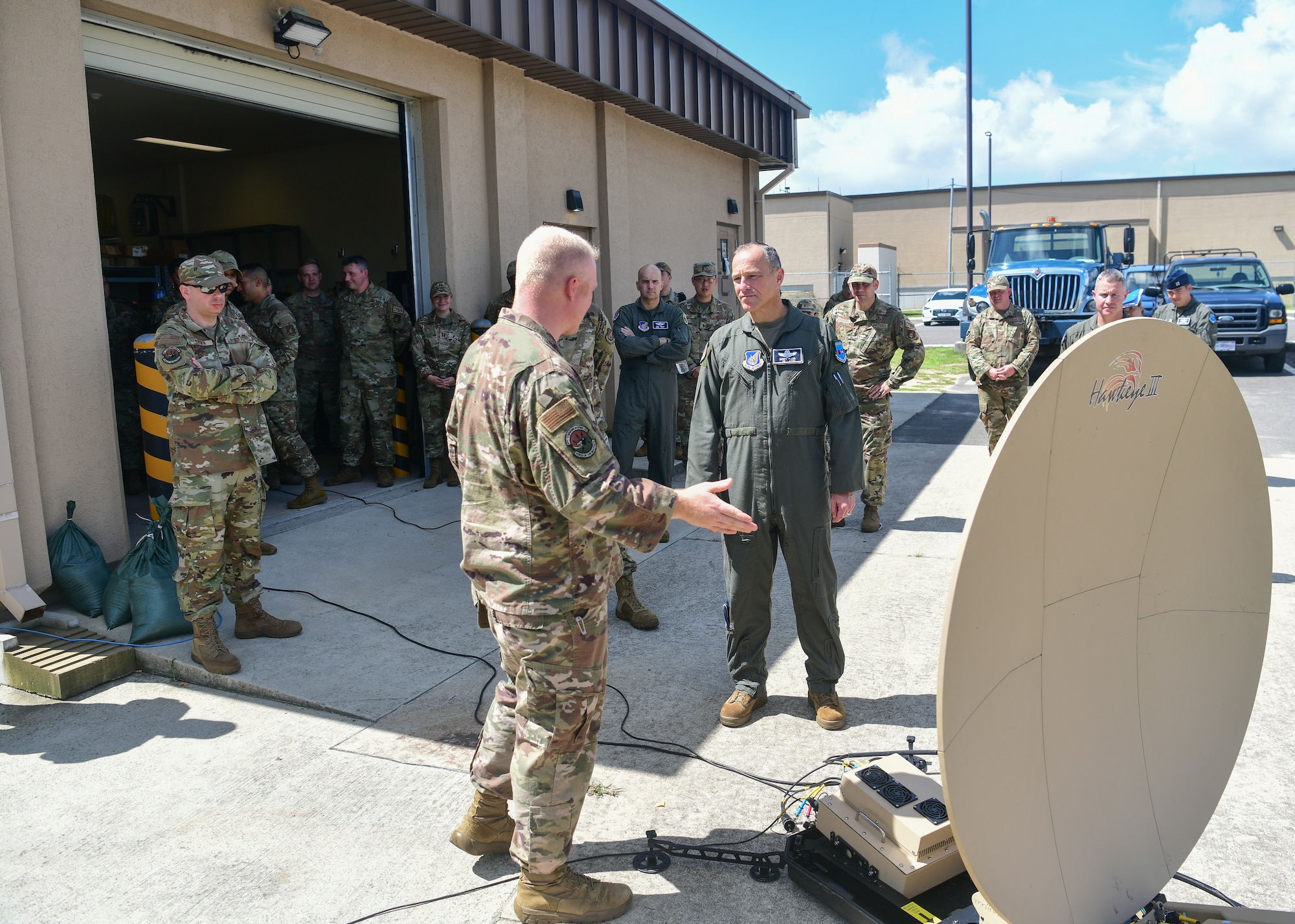 Military members talk around a satellite dish.