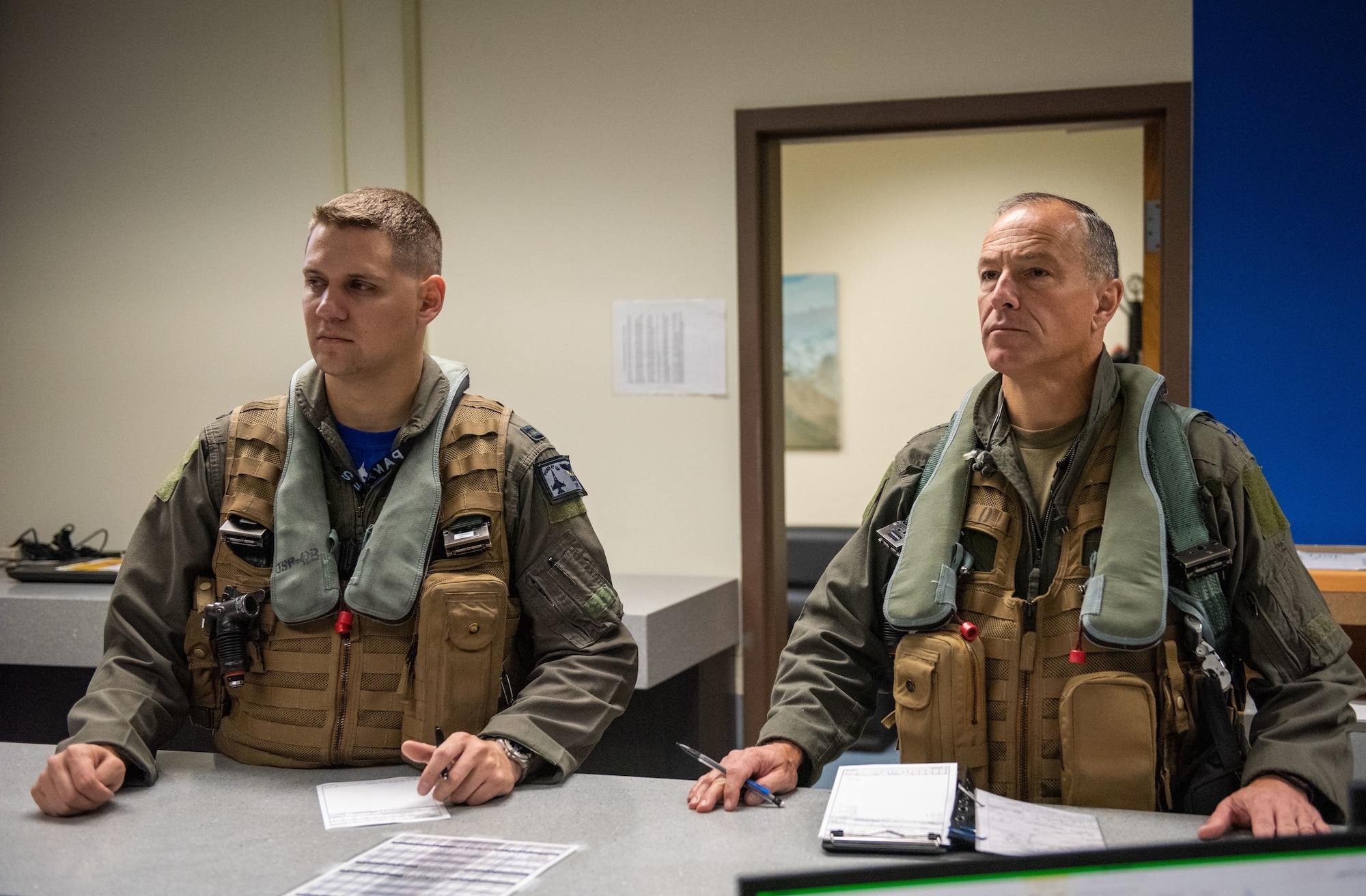 Two military pilots receive a brief.