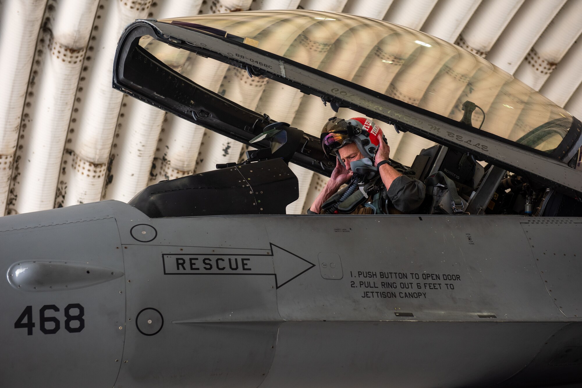 A military member sits inside a military jet.