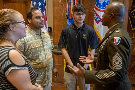Command Sgt. Maj. Kenneth F. Law, U.S. Army Financial Management Command senior enlisted advisor, talks with Dante Carney, a New Haven High School senior and future U.S. Army Soldier, and his parents about the benefits of Army life during a Future Soldier Recognition Event at the Indiana War Memorial in Indianapolis Aug. 5, 2022. The event included remarks from influential Army leaders, awards and recognition, and networking opportunities for future Soldiers waiting to ship out to basic combat training. (U.S. Army photo by Mark R. W. Orders-Woempner)