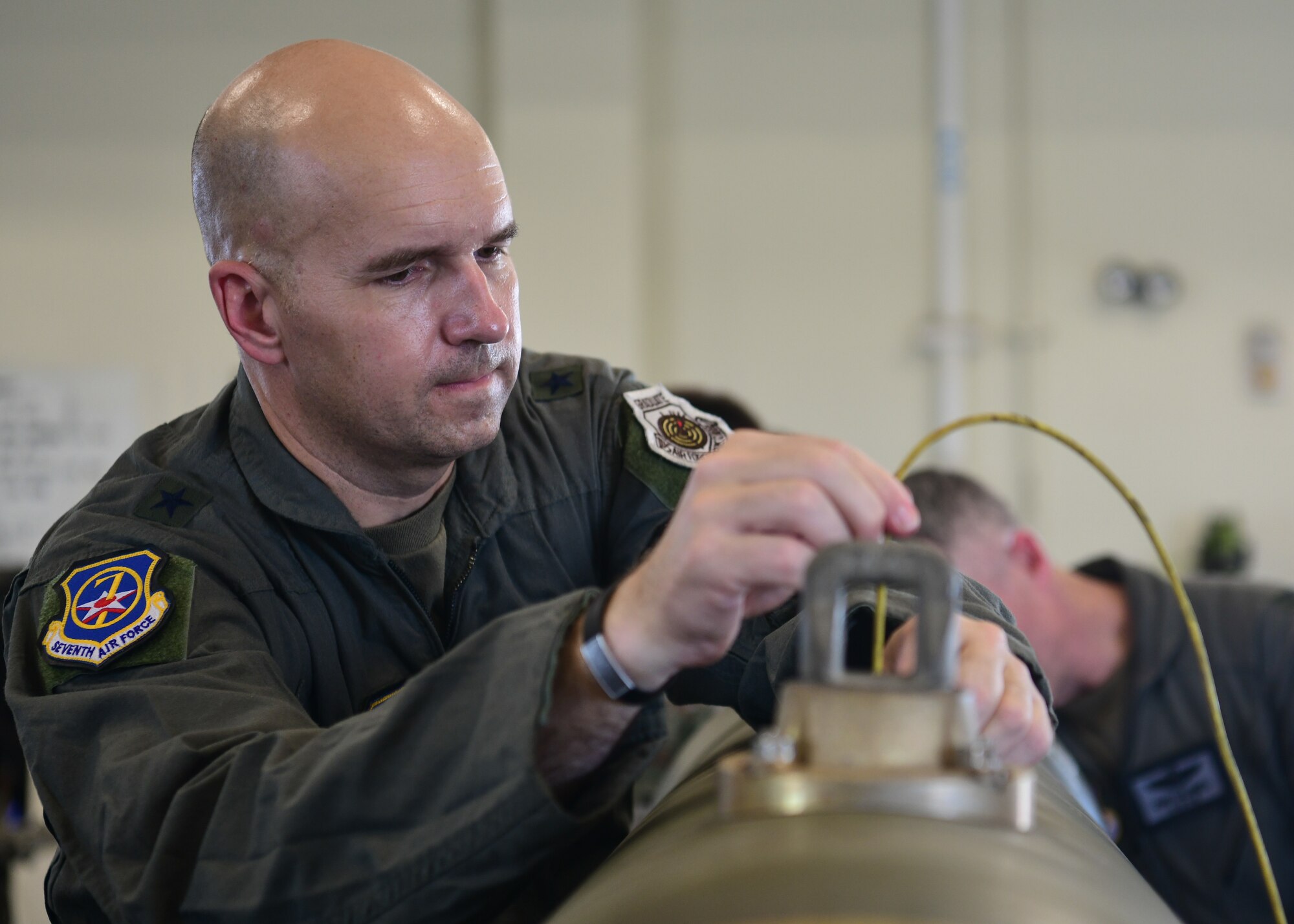 A military member works on a munition.