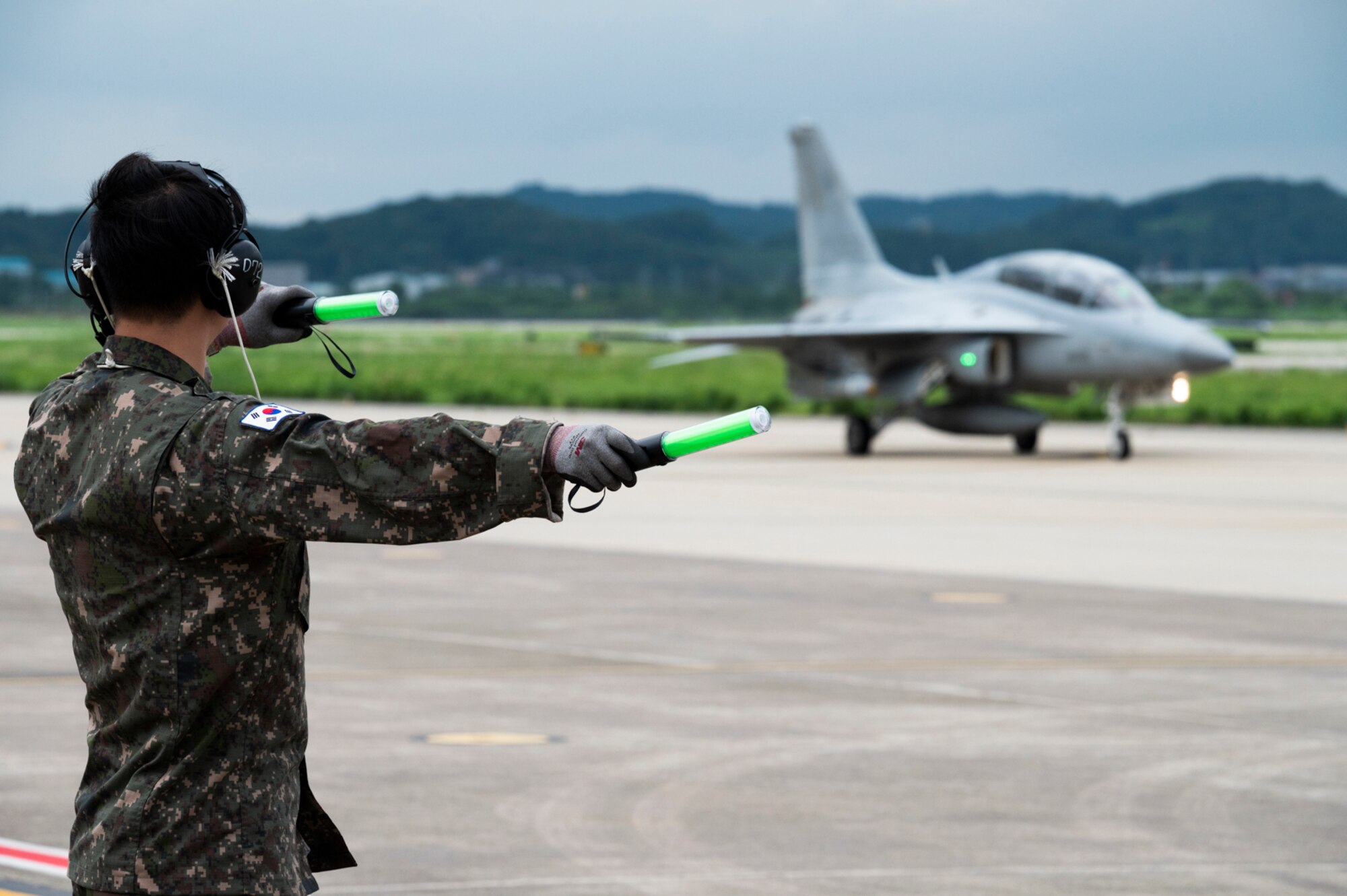 A Republic of Korea Air Force maintainer guides a FA-50 Golden Eagle as it taxis off the runway during Buddy Squadron 22 at Osan Air Base, Republic of Korea, Aug 2, 2022.