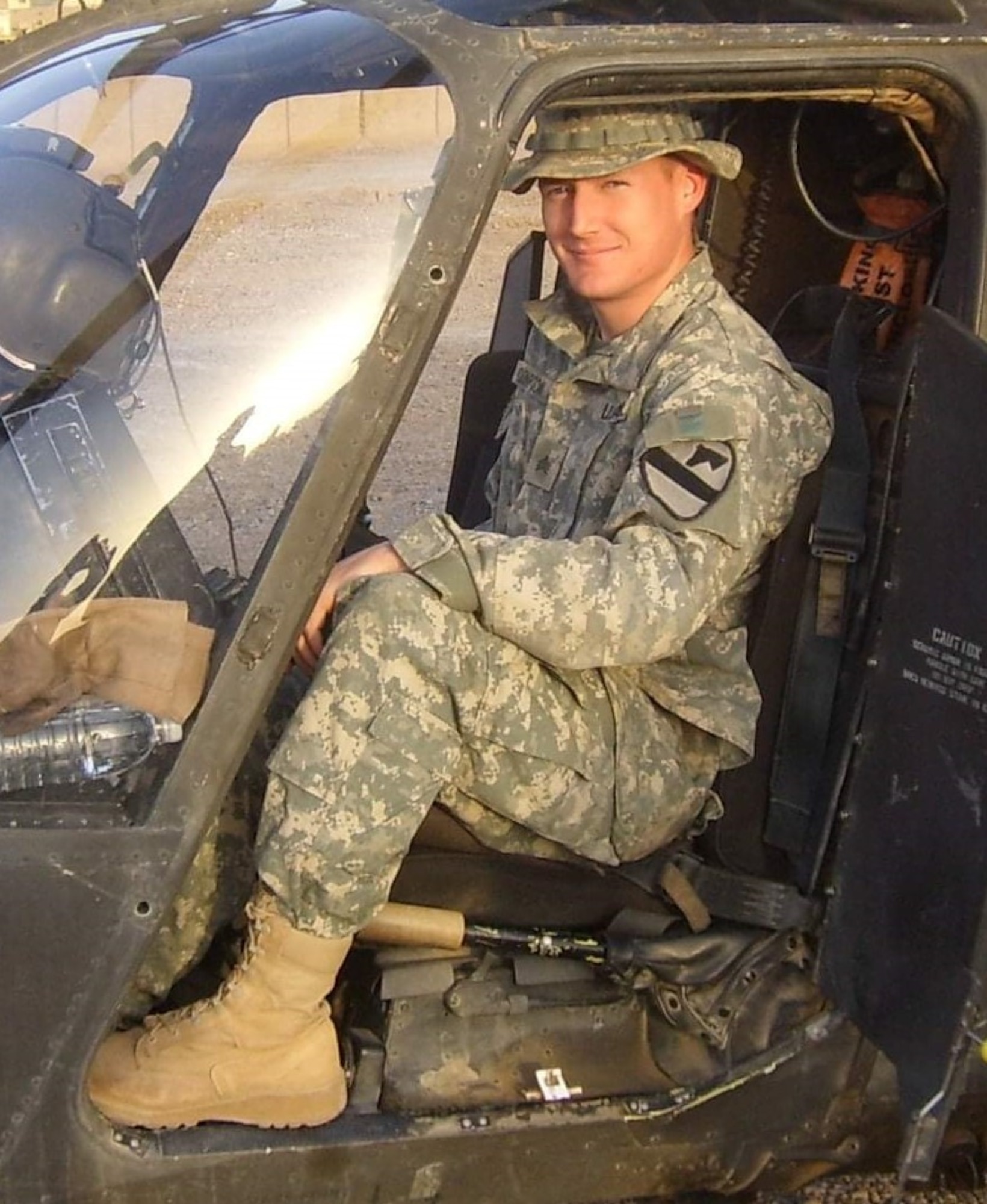 Man in military uniform sitting in a military vehicle