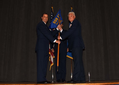 a man passes a guidon to another man