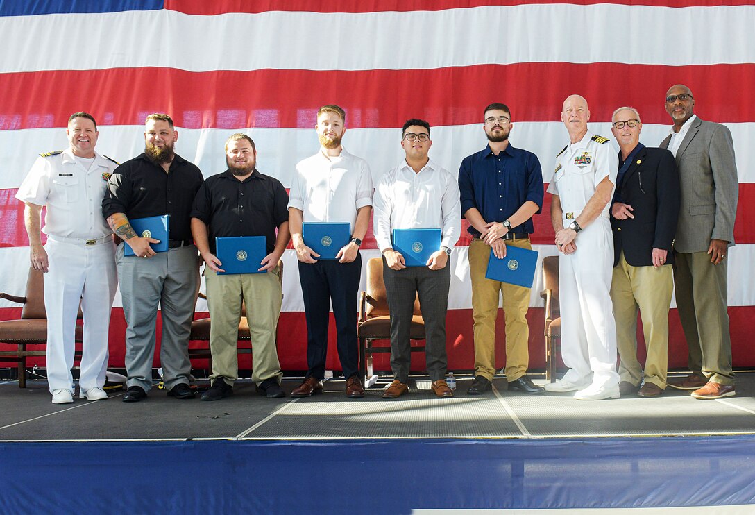 New journey-level artisans who graduated from Fleet Readiness Center Southeast’s (FRCSE) Trades Apprenticeship Program pose for a picture with FRCSE leadership after receiving their certificates of completion. FRCSE launched the renewed apprenticeship program in 2019, a combination work-study program that provides apprentices with a competitive wage and benefits while learning a journey-level trade. L to R: LCDR Joel DeGraeve, Joshua Lancaster, Andre Giannini, Robert Boehnel, Gilbert Baez, John McCarthy, CAPT Grady Duffey, Mr. Joe Pickens, and Reginald Valentine. (U.S. Navy Photo by Toiete Jackson/Released)