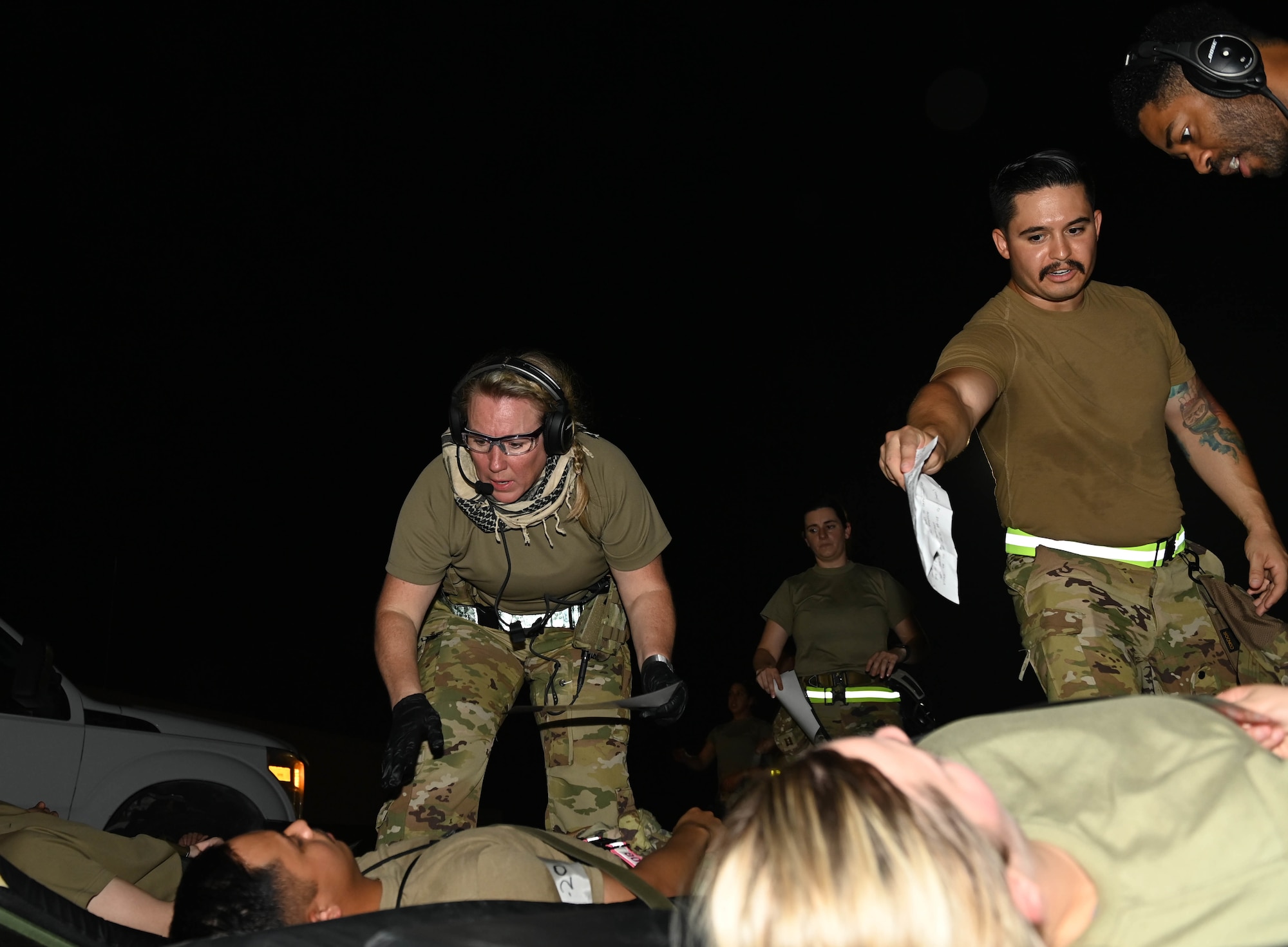 U.S. Air Force Lt. Col. Michelle Lambert (left), a 379th Expeditionary Air Evacuation Squadron flight nurse, along with other medical staff assess patients during an exercise Aug 4, 2022 at Al Udeid Airbase, Qatar. The medical evacuation staff quickly assessed the status of the patients and began loading them onto the aircraft. (U.S. Air National Guard photo by Master Sgt. Michael J. Kelly)