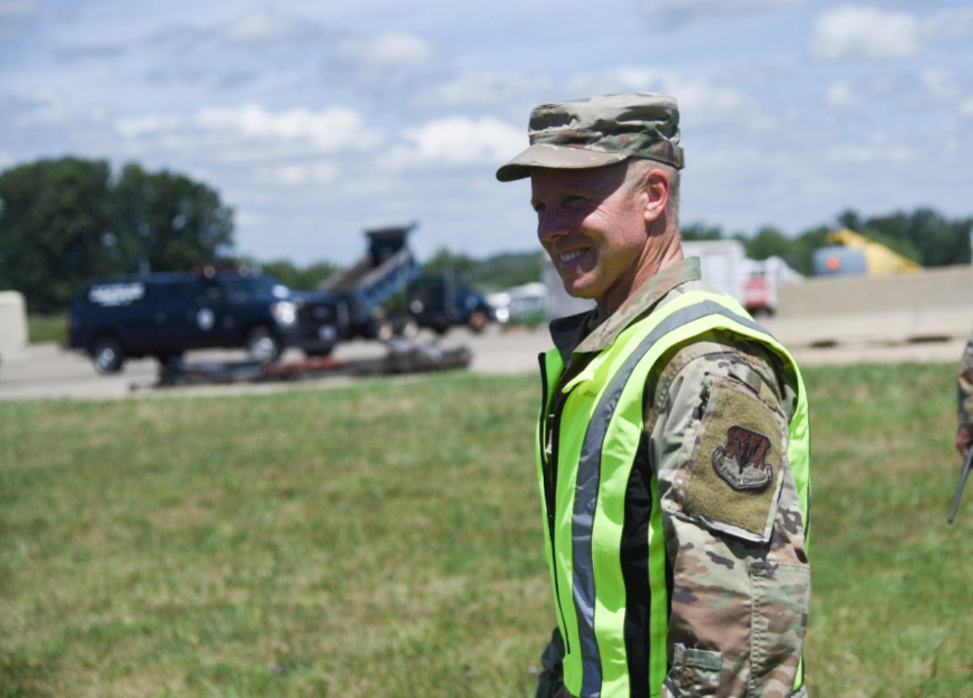 Man in military uniform wearing a fluorescent vest.