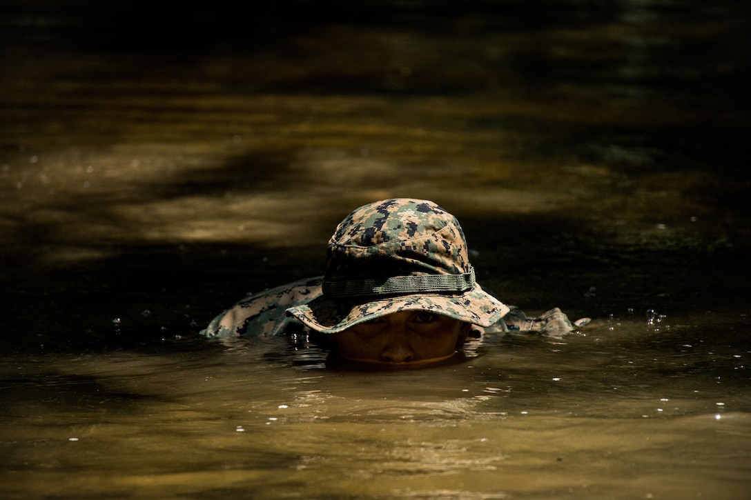 Lance Cpl. Liam C. Doyle, a machine-gunner with Guard Company, Marine Barracks Washington, searches for his checkpoint in a river at Marine Corps Base Quantico, Va., Aug 3, 2022. The Marines participated in an air insert with MV-22 Ospreys, and implemented their infantry training tactics by conducting land navigation and performing casualty evacuation scenarios.