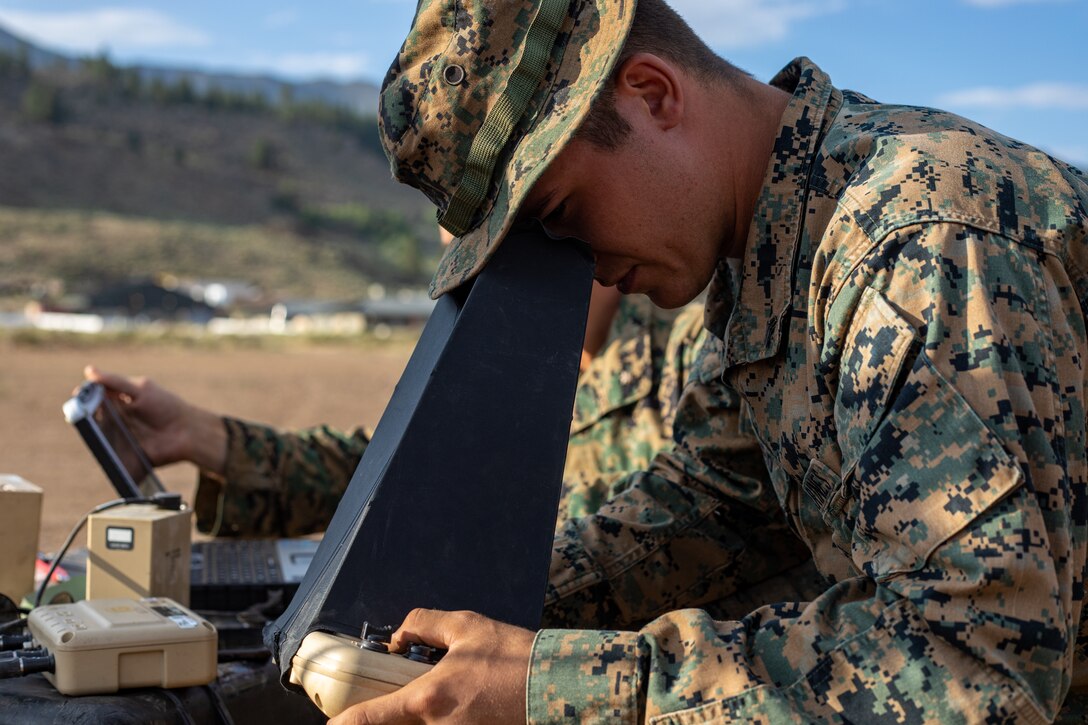 Cpl. Cole Millard, a Raven-B RQ-11 operator and intelligence specialist with H&S Company, 1st Battalion, 24th Marine Regiment, 4th Marine Division, Marine Forces Reserve, observes a Raven-B RQ-11 drone in flight through a Raven-B RQ-11 controller device at Marine Corps Mountain Warfare Training Center, Bridgeport, Calif., July 27, 2022, for Mountain Training Exercise 4-22. MTX 4-22 prepares Marines for the challenges of operating in a harsh, mountainous environment many of their adversaries are acclimated to. (U.S. Marine Corps photo by Cpl. Jonathan L. Gonzalez)