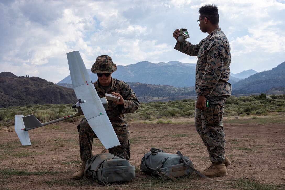 Cpl. Cole Millard, left, a Raven-B RQ-11 operator, and Lance Cpl. Jordan Baker, with H&S Company, 1st Battalion, 24th Marine Regiment, 4th Marine Division, Marine Forces Reserve, set up and prepare to launch a Raven-B RQ-11 drone at Marine Corps Mountain Warfare Training Center, Bridgeport, Calif., July 27, 2022, for Mountain Training Exercise 4-22. MTX 4-22 prepares Marines for the challenges of operating in a harsh, mountainous environment many of their adversaries are acclimated to. (U.S. Marine Corps photo by Cpl. Jonathan L. Gonzalez)