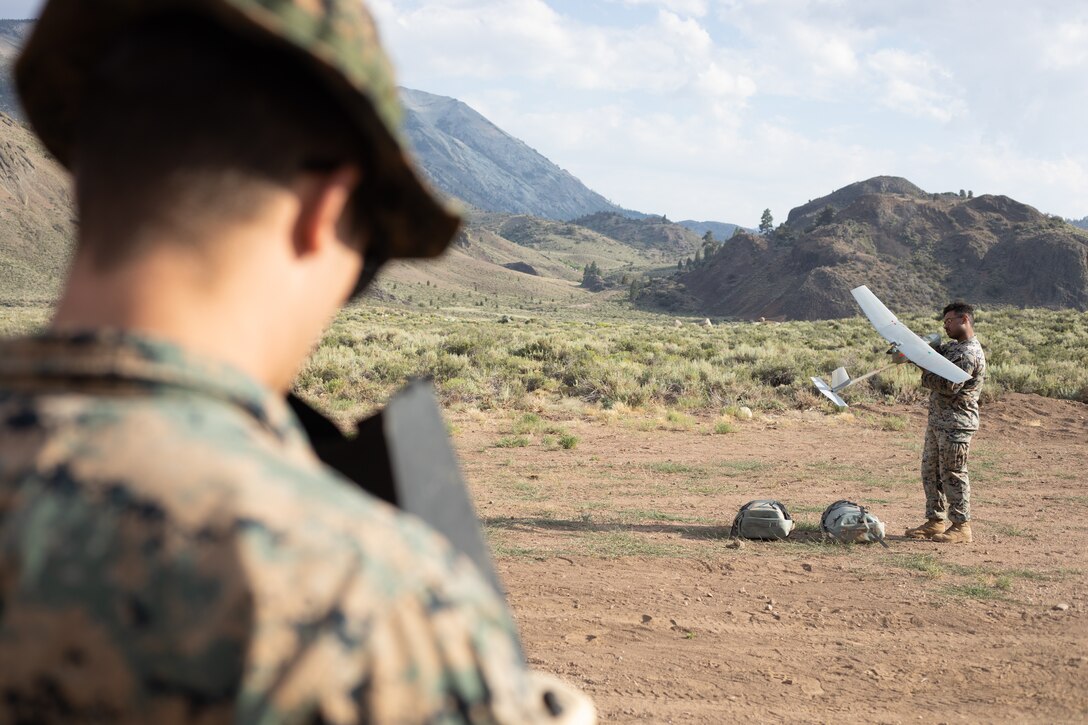 Cpl. Cole Millard, left, a Raven-B RQ-11 operator, and Lance Cpl. Jordan Baker, with H&S Company, 1st Battalion, 24th Marine Regiment, 4th Marine Division, Marine Forces Reserve, set up and prepare to launch a Raven-B RQ-11 drone at Marine Corps Mountain Warfare Training Center, Bridgeport, Calif., July 27, 2022, for Mountain Training Exercise 4-22. MTX 4-22 allowed reserve Marines to participate in mountain warfare operations for realistic combat training to facilitate increased readiness for the Marine Forces Reserve. (U.S. Marine Corps photo by Cpl. Jonathan L. Gonzalez)