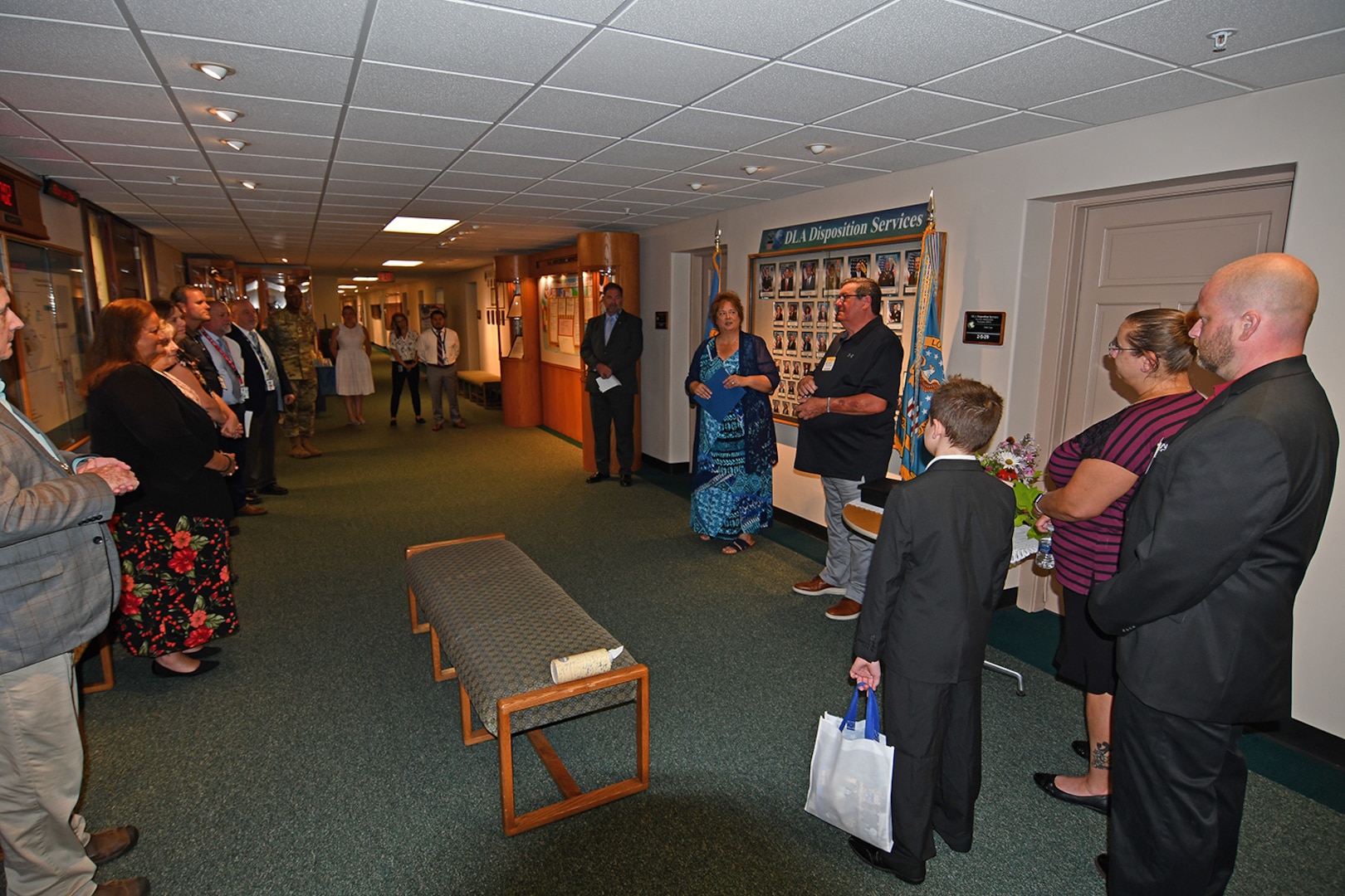 A group of people gather in a hallway.