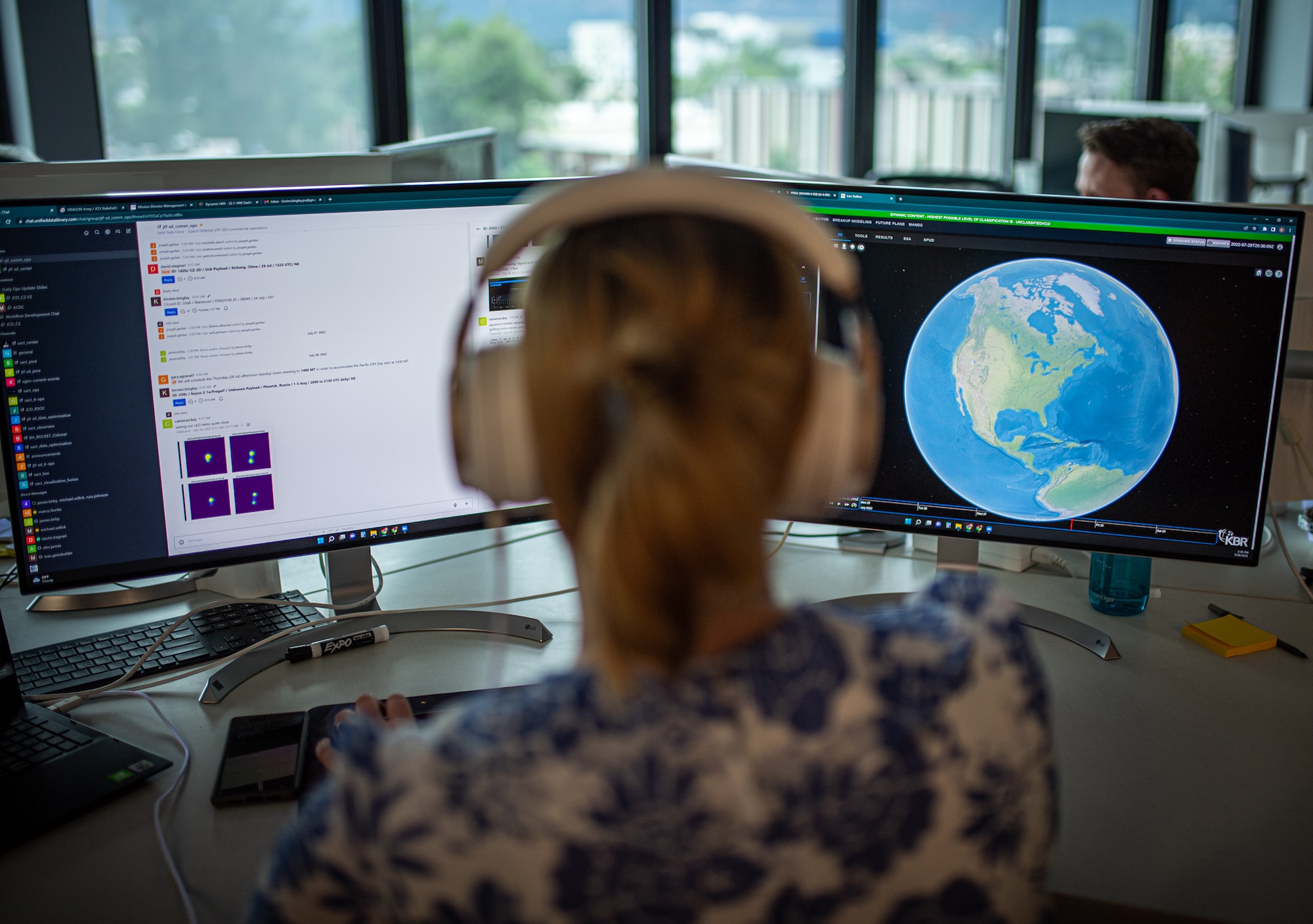 Woman sitting at two computer screens