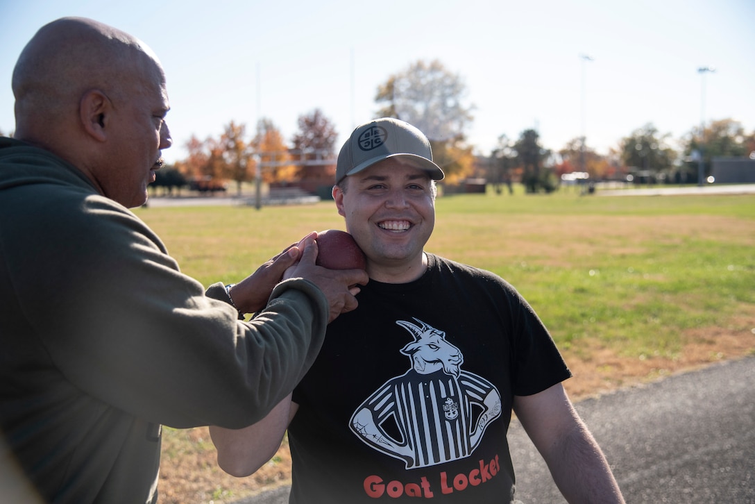 Blake Conley works with a coach while learning shot put.