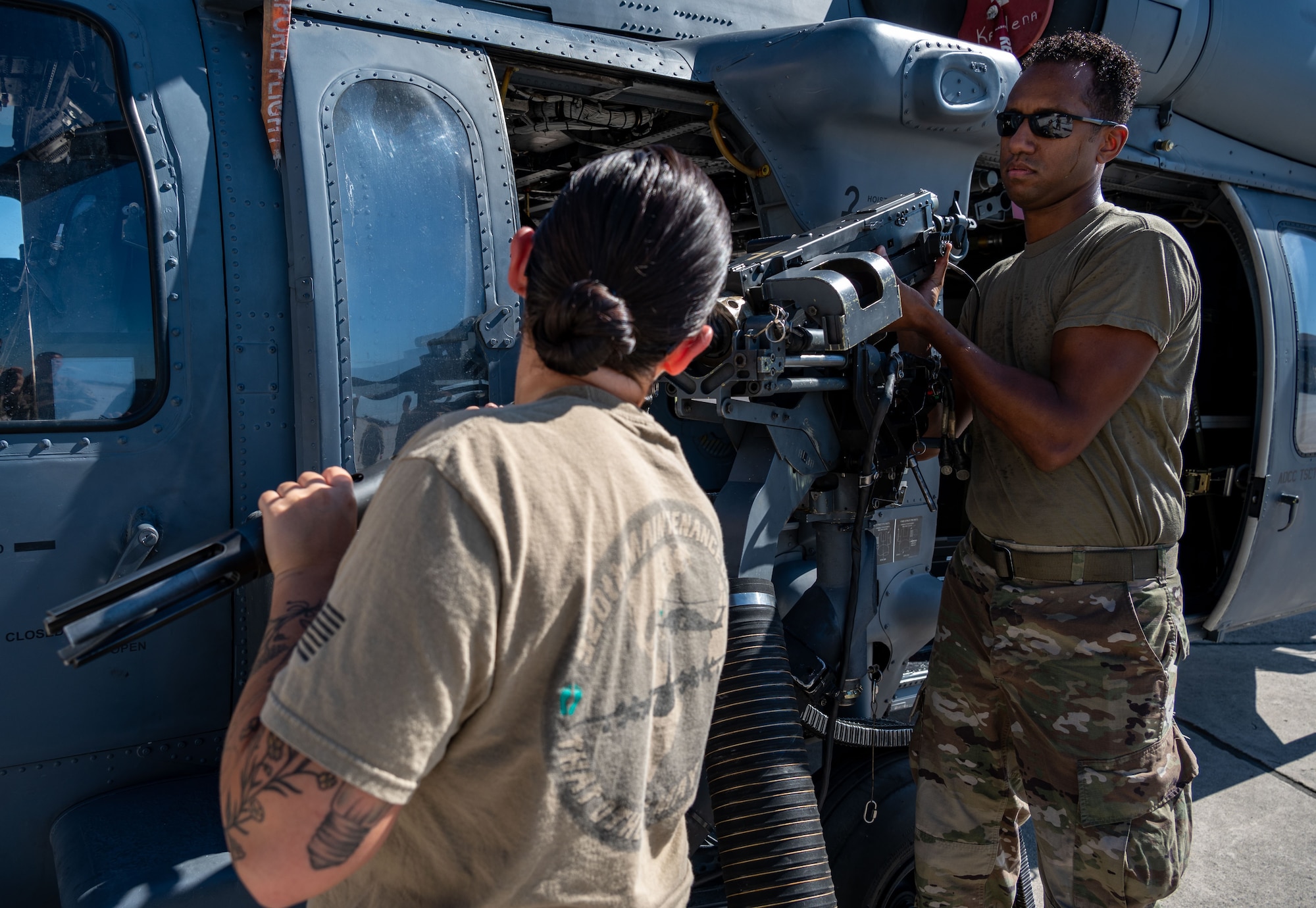 Senior Airman Andrew Hernandez and Staff Sgt. Taylor Bender, 920th AMXS weapons load crew members, remove a GAU-18 machine gun from a 920th Rescue Wing HH-60G Pave Hawk helicopter Aug. 6, 2022 at Patrick Space Force Base, Florida. (U.S. Air Force photo by Master Sgt. Kelly Goonan)