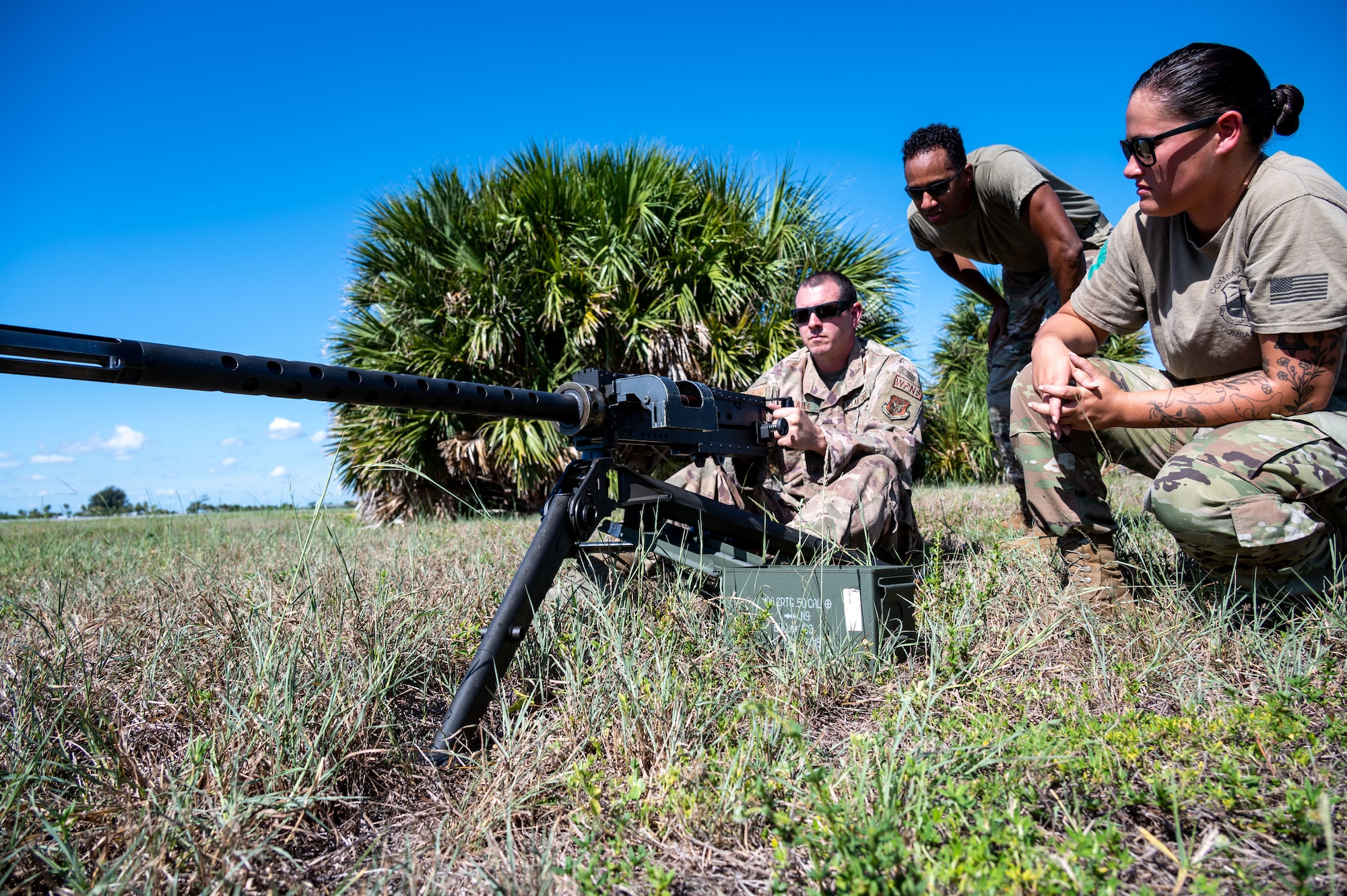 Technical Sgt. Tony Blaile, 920th Aircraft Maintenance Squadron weapons expeditor, Senior Airman Andrew Hernandez and Staff Sgt. Taylor Bender, 920th AMXS weapons load crew members, check the balance of a GAU-18 machine gun on the lightweight tripod mount helicopter Aug. 6, 2022 at Patrick Space Force Base, Florida. (U.S. Air Force photo by Master Sgt. Kelly Goonan)