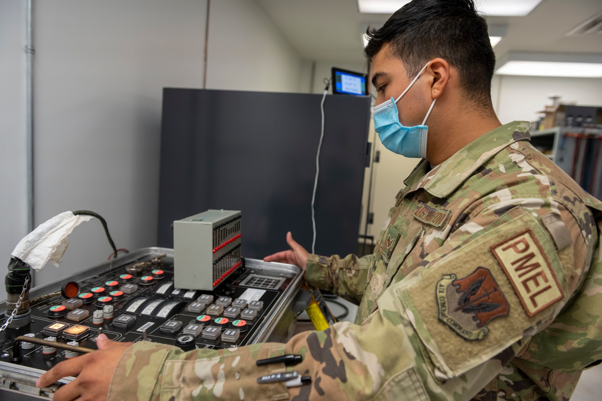 Senior Airman Manuel Martinez Dubray, 4th Component Maintenance Squadron precision measurement equipment laboratory (PMEL) electronics technician, examines a control stick boost and pitch compensator (CSBPC) test set at Seymour Johnson Air Force Base, North Carolina, Aug. 3, 2022. The CSBPC test set is used to ensure the control stick of an F-15E Strike Eagle is working properly. (U.S. Air Force photo by Senior Airman Kevin Holloway)
