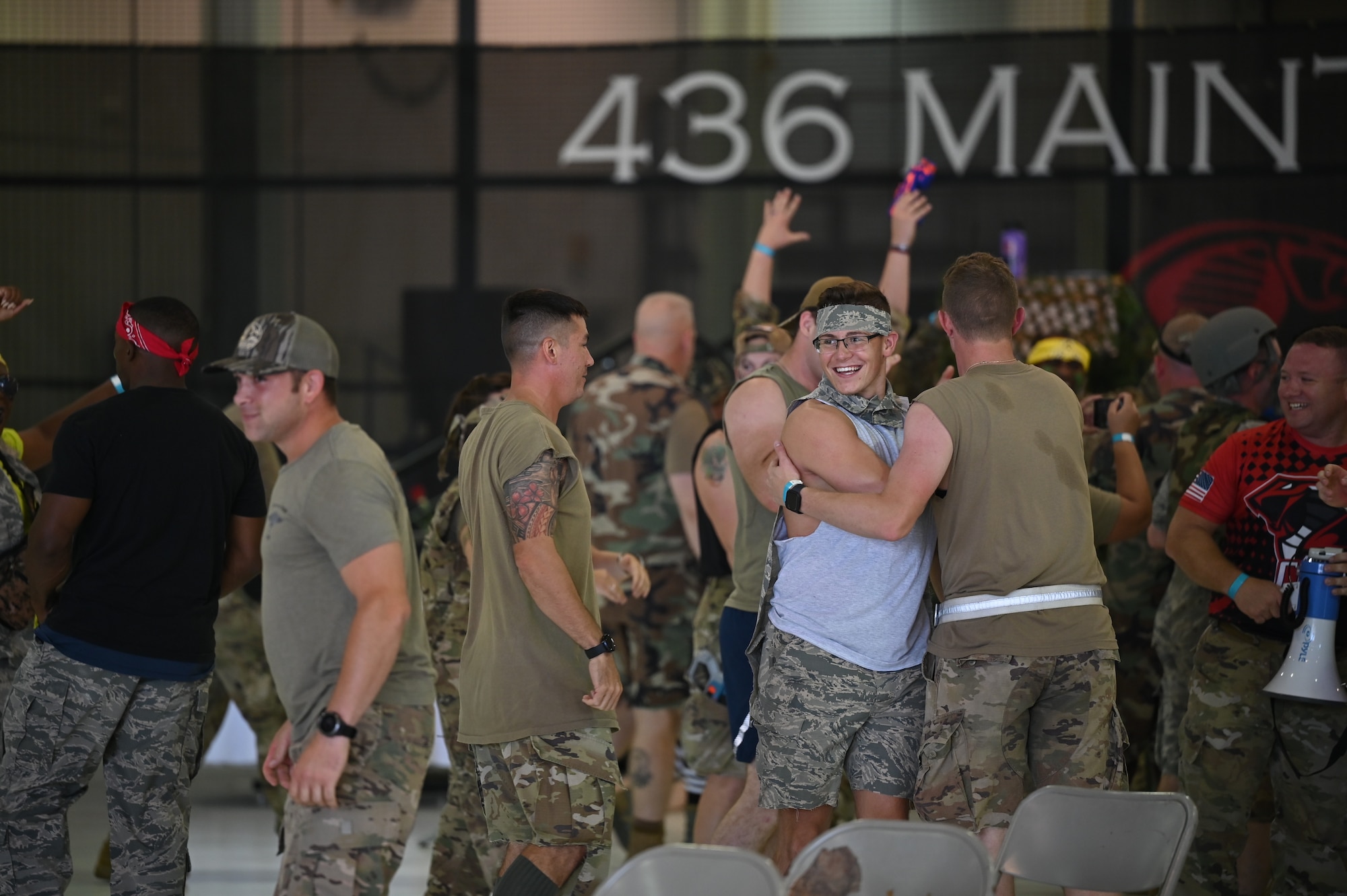 Team Dover Airmen celebrate a tug-of-war win during the Combat Dining-In on Dover Air Force Base, Delaware, Aug. 5, 2022. Airmen represented their respective group in a series of challenges that included tug-of-war and Nerf gun battles. The gathering gave commanders and their Airmen a chance to interact in an unofficial capacity. (U.S. Air Force photo by Staff Sgt. Marco A. Gomez)