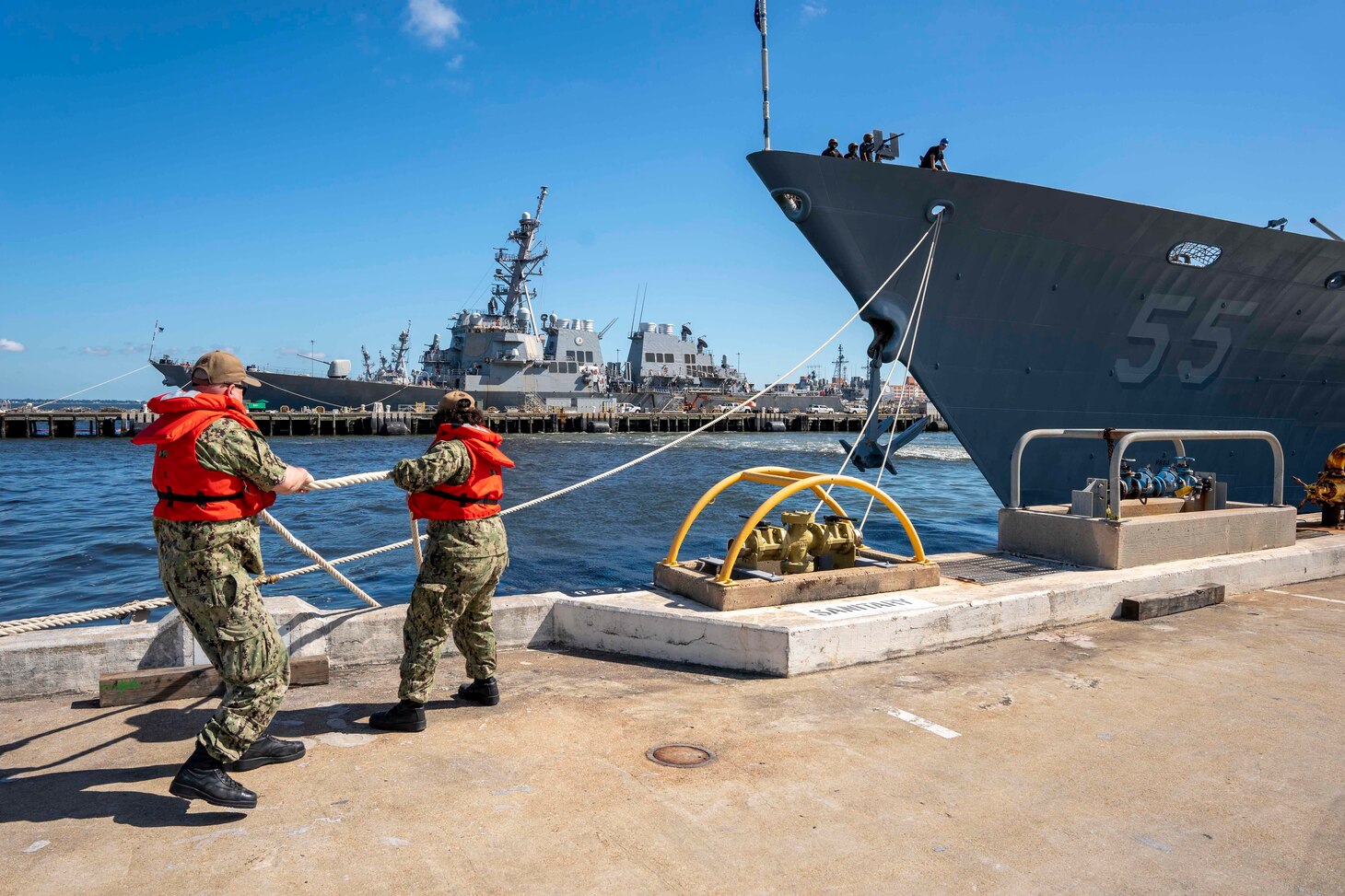 Line handlers cast off mooring lines from the pier as the Ticonderoga-class guided-missile cruiser USS Leyte Gulf (CG 55) gets underway aboard Naval Station Norfolk.
