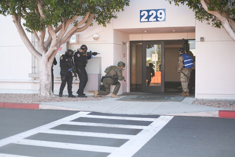 Security from on and off base approach the entrance to the building looking for the active shooter.