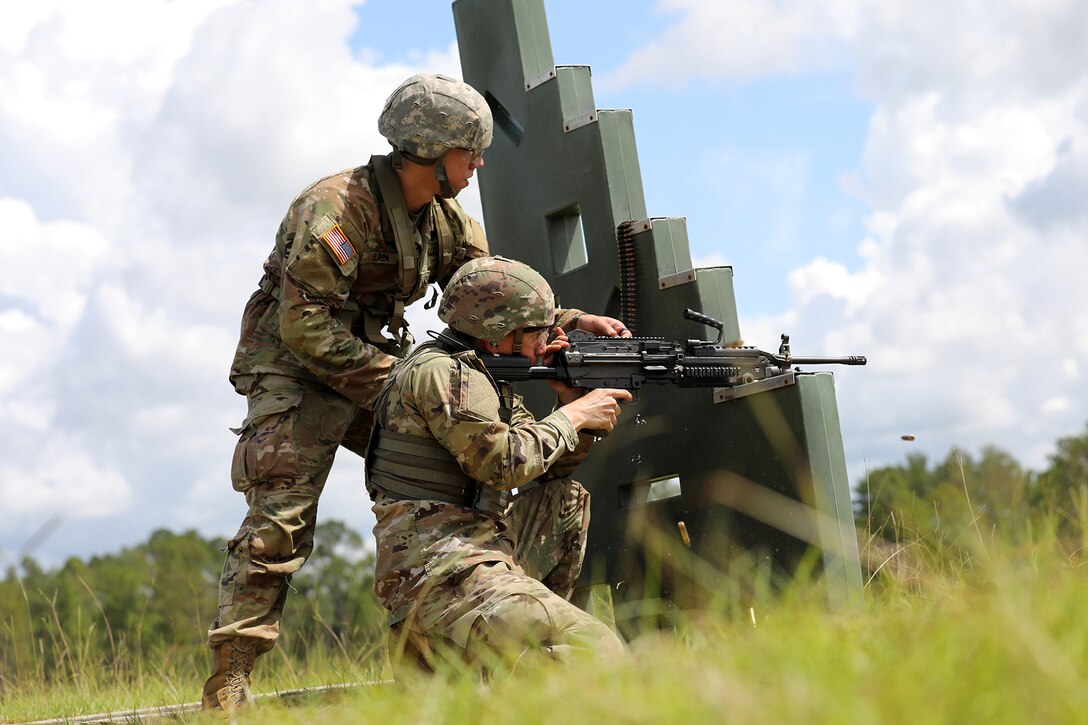 Pfc. Erick Baza, left, 31 Bravo, 810th Military Police Company, Tampa, Florida calls out targets for Spc. Gabriel Serafini, 31 Bravo, 810th Military Police Company, firing the M-249 during lanes training at Pershing Strike.
