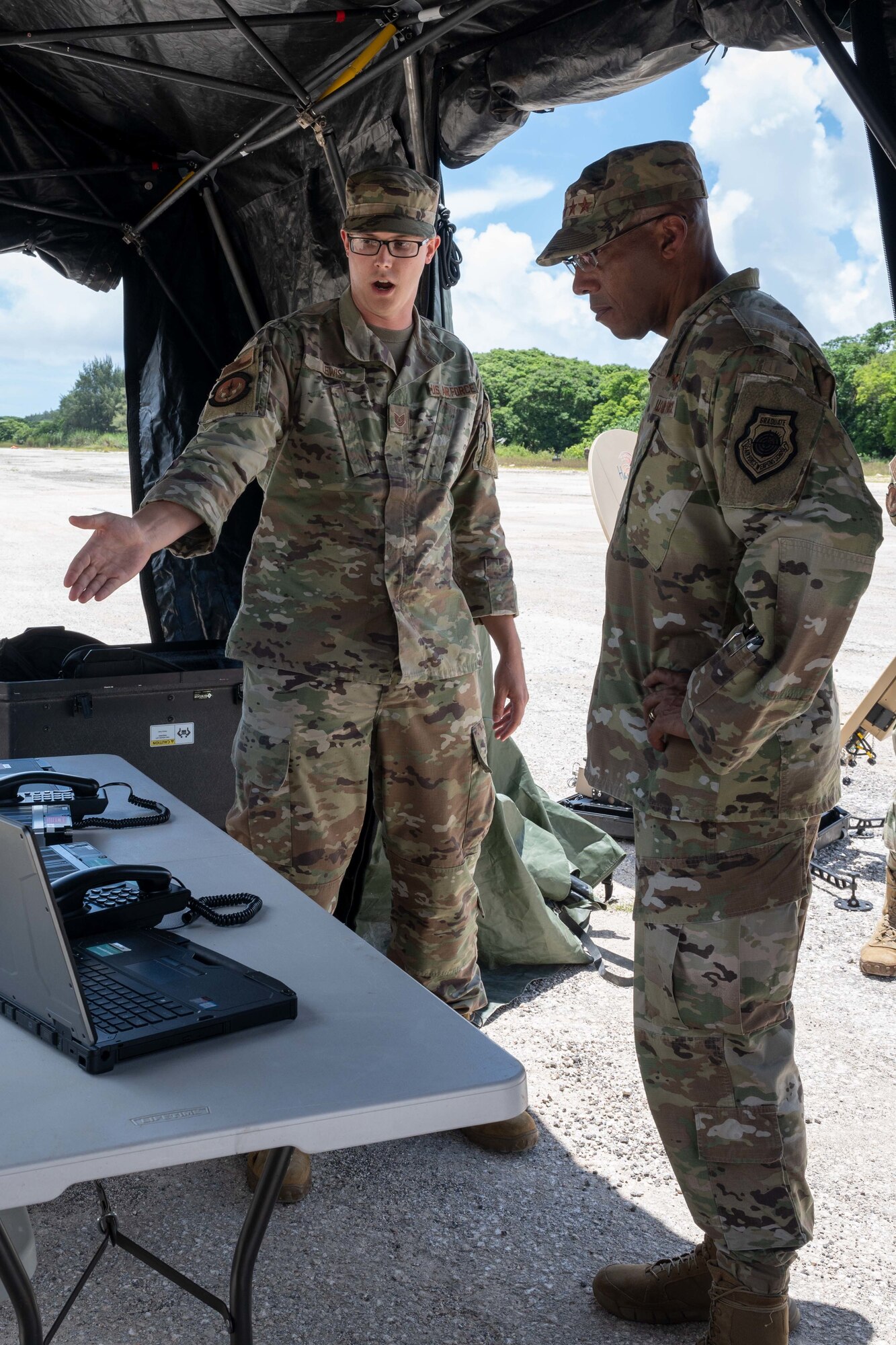 U.S. Air Force Chief of Staff Gen. CQ Brown, Jr. is briefed by U.S. Air Force Tech Sgt. Robert Lewis, noncommissioned officer in charge of the communications information flight with the 36th Contingency Response Squadron about the communication capabilities in the Indo-Pacific region at Northwest Field, Guam, Aug. 7, 2022.