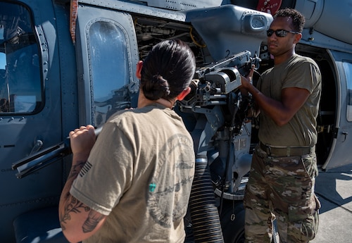 Senior Airman Andrew Hernandez and Staff Sgt. Taylor Bender, 920th AMXS weapons load crew members, remove a GAU-18 machine gun from a 920th Rescue Wing HH-60G Pave Hawk helicopter Aug. 6, 2022 at Patrick Space Force Base, Florida. (U.S. Air Force photo by Master Sgt. Kelly Goonan)