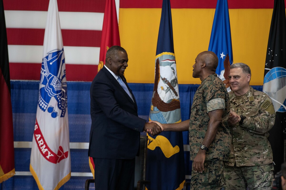 Secretary of Defense Lloyd J. Austin III shakes hands with Marine Corps Gen. Michael E. Langley.