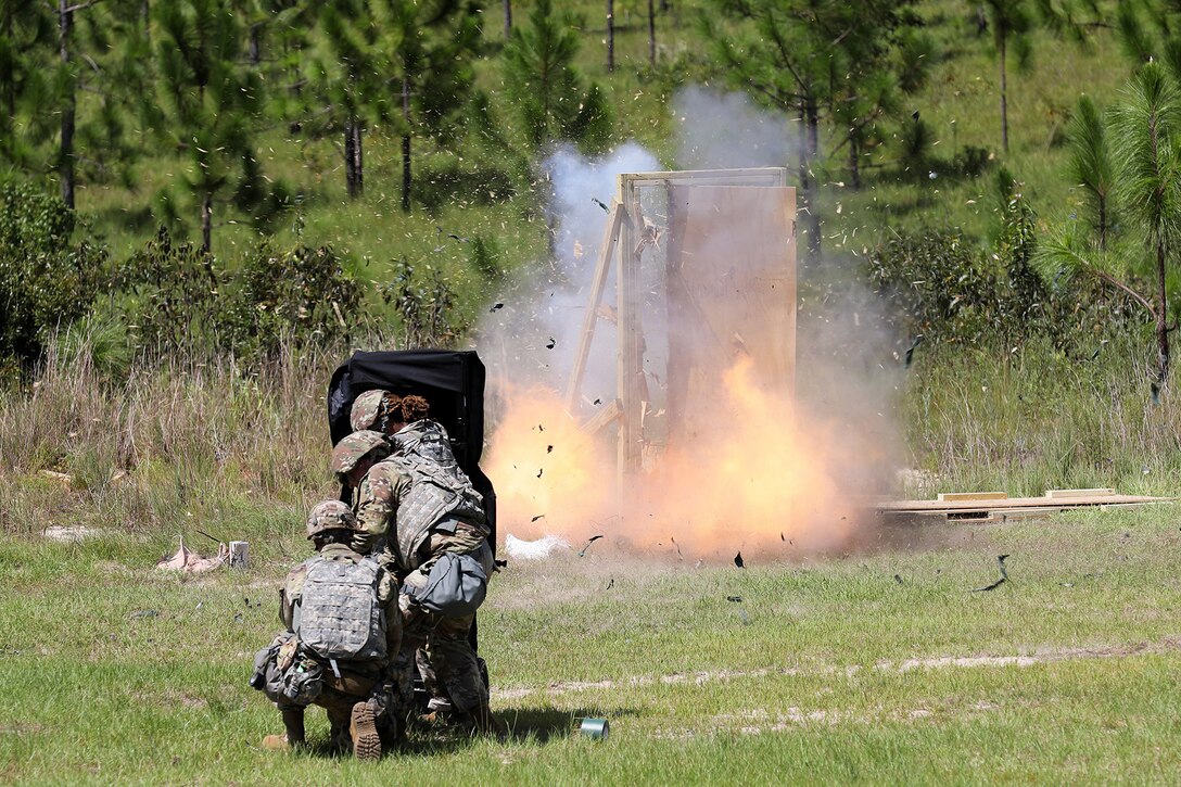 U.S. Army Reserve Soldiers, assigned to the 344th Engineer Company based in Tallahassee, Florida, take cover behind a blast blanket while detonating a linear det charge placed on a door hinge to create an entry point during the Pershing Strike mobilization exercise.