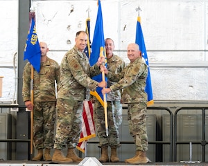 Col. Matt Husemann, left, 436th Airlift Wing commander, passes the guidon of the newly activated 436th Mission Generation Group to Col. Bary Flack, 436th MGG commander, at Dover Air Force Base, Delaware, June 6, 2022. The 436th Logistics Readiness Squadron became part of the 436th Maintenance Group to form the 436th MGG (Provisional) for a two-year test. (U.S. Air Force photo by Mauricio Campino)