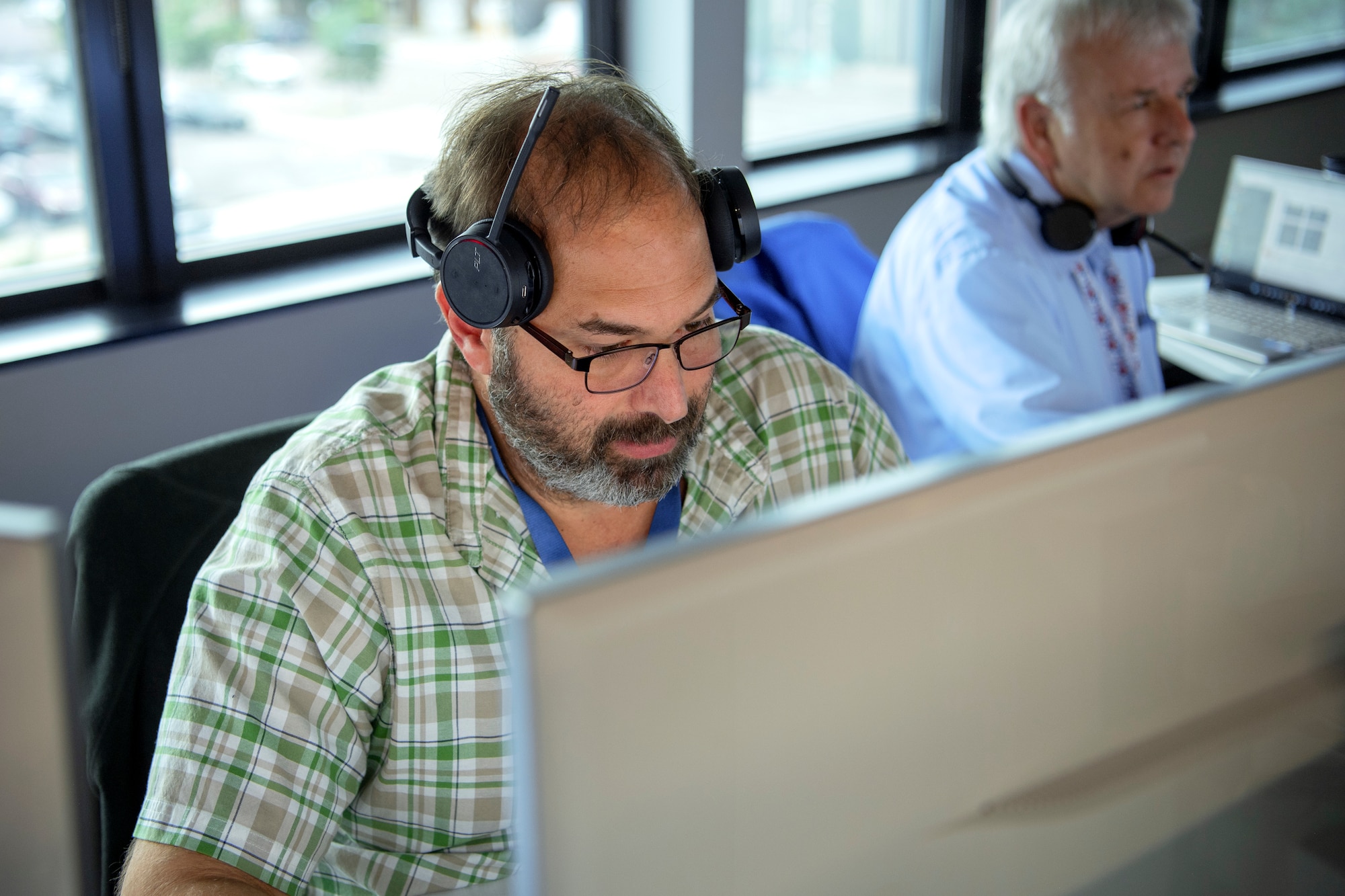 Two men sitting at computer screens