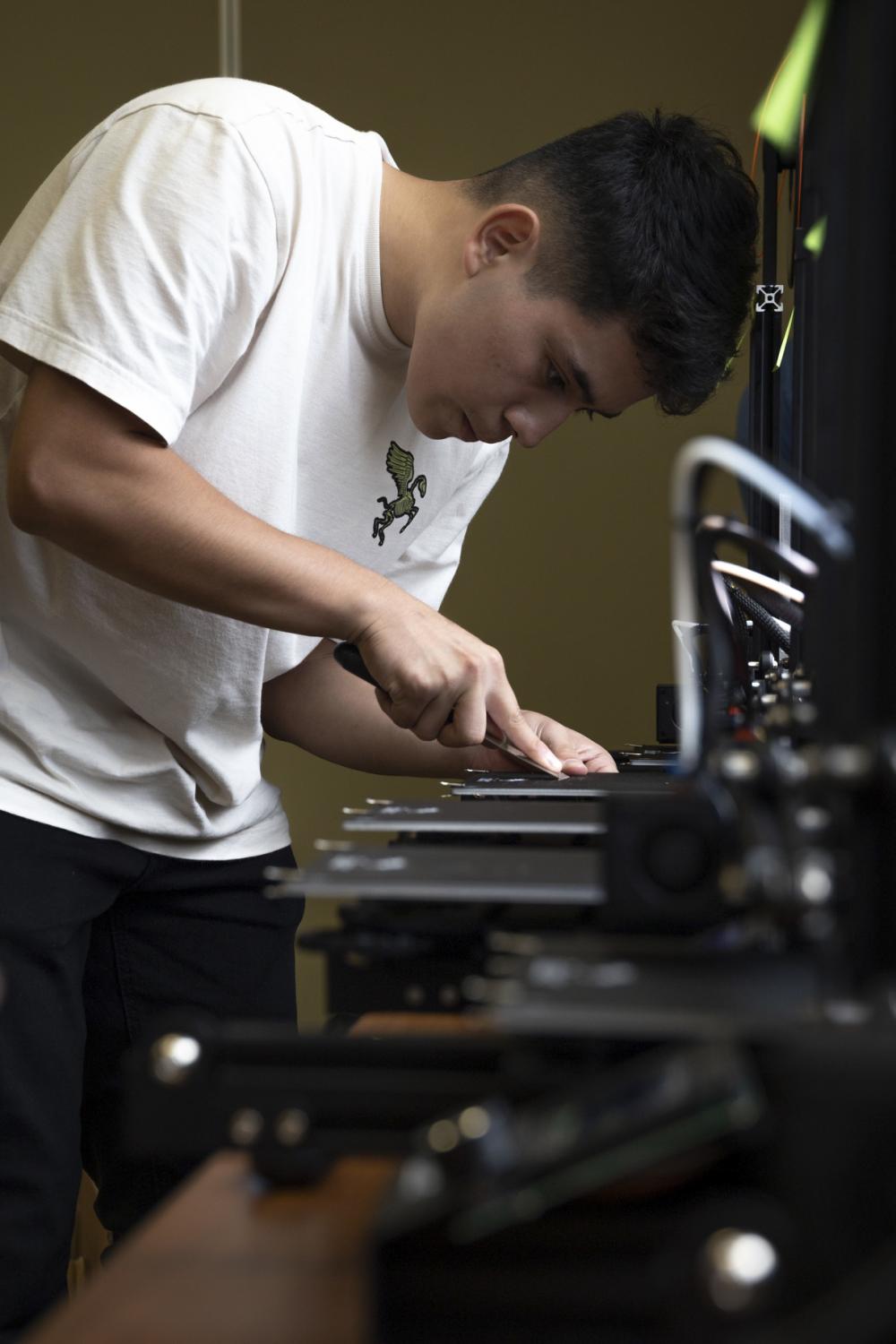 U.S. Marine Corps Cpl. Alexis Trejogarrido, a telephone systems/personal computer repairs technician with 7th Communication Battalion, III Marine Expeditionary Force Information Group, scrapes filament off of a 3D printer during Innovation Boot Camp (IBC) on Camp Hansen, Okinawa, Japan, Aug. 1, 2022. IBC was designed to teach Marines skills such as welding, 3D printing, coding, and programming to create innovative products for the Marine Corps and to test Marines’ critical thinking skills. Trejogarrido is a native of Mesa, Arizona. (U.S. Marine Corps photo by Sgt. Savannah Mesimer)