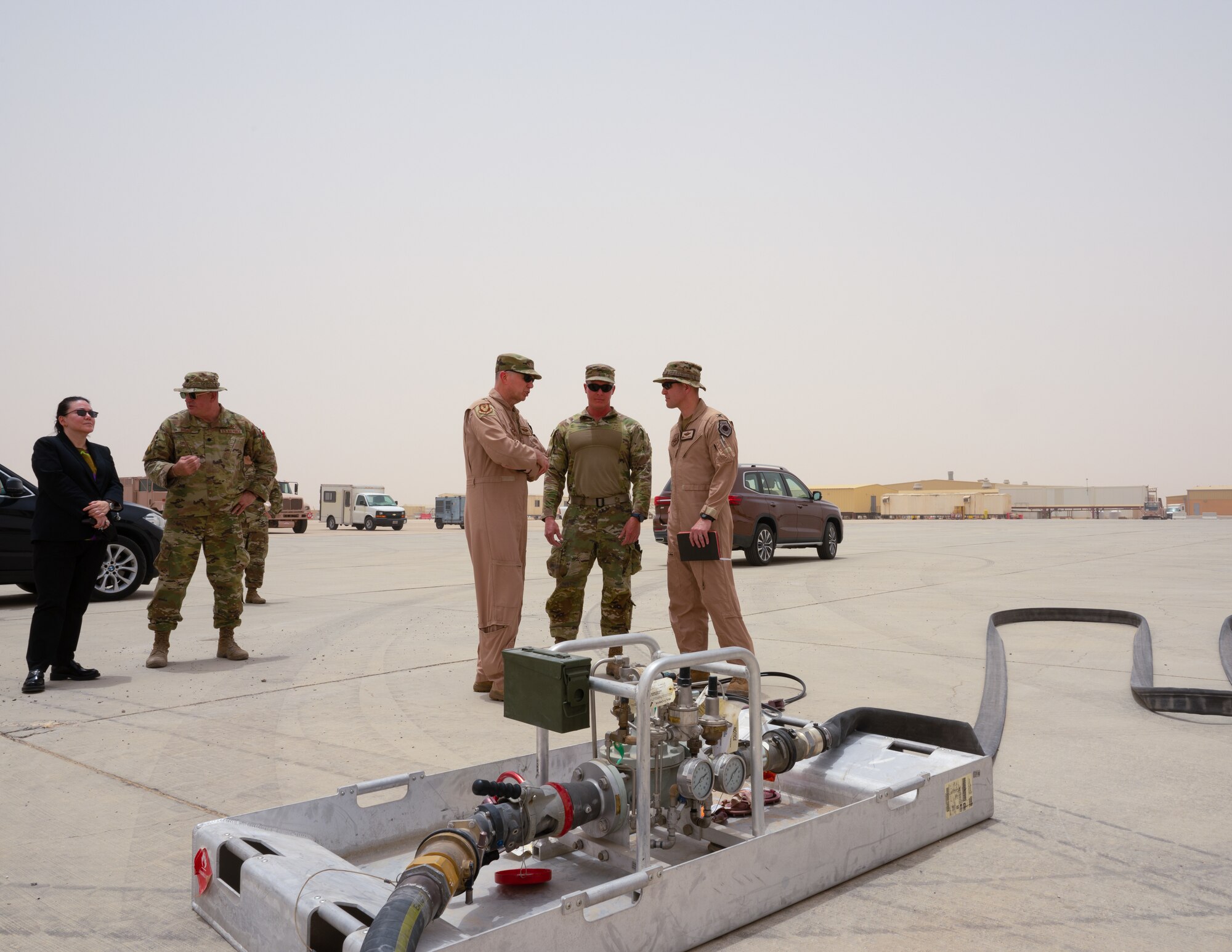 Leslie M. Tsou, far left, U.S. ambassador to the Sultanate of Oman, and U.S. Air Force Lt. Gen. Gregory M. Guillot, center left, commander, Ninth Air Force (Air Forces Central) receive a brief from U.S. Air Force Master Sgt. Joshua Oberheu, center, a petroleum oil and lubricants specialist with the 379th Expeditionary Logistics Readiness Fuels Flight, during Accurate Test 22, Royal Air Force of Oman Thumrait Air Base, May 15, 2022. Oberheu invented a new method of aircraft to aircraft refueling by modifying existing equipment to reduce waste and increase efficiency of operations.  (U.S. Air Force photo by Staff Sgt. Dana Tourtellotte)