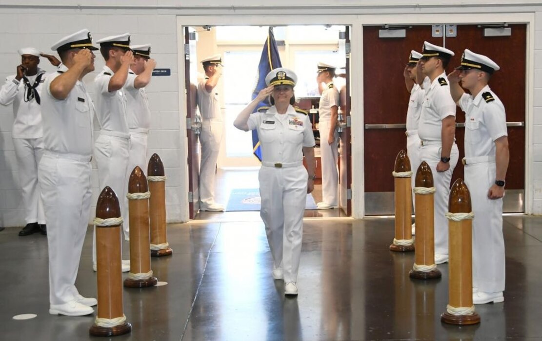 GREAT LAKES, Ill. (June 27, 2022) – Commander, Naval Service Training Command (NSTC), Rear Adm. Jennifer S. Couture, receives arrival honors during a graduation ceremony for Naval Reserve Officers Training Corps (NROTC) New Student Indoctrination (NSI) Cycle 1 midshipman candidates inside the Midway Ceremonial Drill Hall at Recruit Training Command (RTC), June 27. Upon completion of NSI, the candidates will start their freshman year of the NROTC program at colleges and universities nationwide this fall. NSI is an indoctrination program hosted at RTC, and provides midshipmen with a common military training orientation. NSI provides basic training in five warfighting fundamentals – firefighting, damage control, seamanship, watchstanding and small arms handling and marksmanship – to begin creating basically trained and smartly disciplined future Navy and Marine Corps officers. NROTC is overseen by NSTC which supports naval accessions training for 98 percent of the Navy’s new officers and enlisted Sailors. (U.S. Navy photo by Scott A. Thornbloom)
