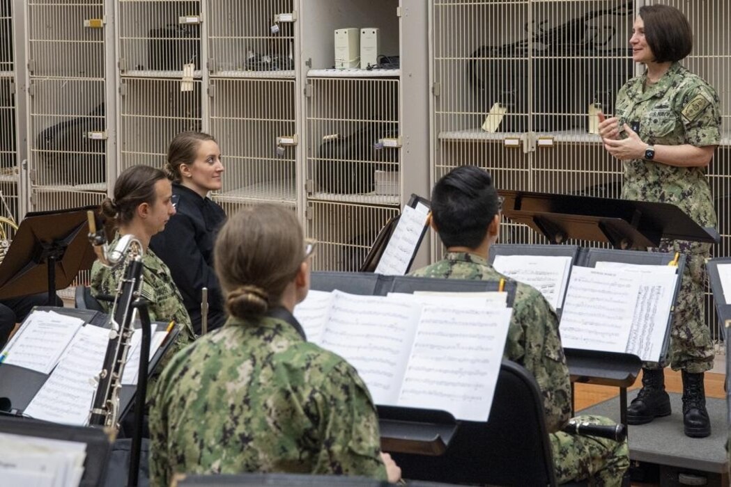220629-N-ZW825-0012 GREAT LAKES, Ill. (June 29, 2022) Commander, Naval Service Training Command (NSTC), Rear Adm. Jennifer Couture speaks with Navy Band Great Lakes musicians during a site visit, June 29. NSTC supports naval accessions training for 98 percent of the Navy’s new officers and enlisted Sailors. This training includes the Naval Reserve Officers Training Corps (NROTC) at more than 160 colleges and universities across the country; Officer Training Command (OTC) in Newport, Rhode Island; Recruit Training Command (RTC), the Navy’s only boot camp; as well as the Navy Junior Reserve Officers Training Corps (NJROTC) and Navy National Defense Cadet Corps (NNDCC) citizenship development program at more than 600 high schools worldwide. (U.S. Navy photo by Chief Mass Communication Specialist Byron C. Linder)