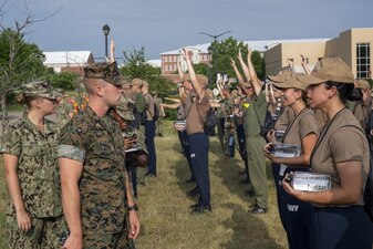 220705-N-ZW825-0011 GREAT LAKES, Ill. (July 5, 2022) Naval Reserve Officers Training Corps (NROTC) New Student Indoctrination (NSI) midshipman candidates recite professional military knowledge in ranks at Recruit Training Command (RTC), July 5. Upon completion of NSI, the candidates will start their freshman year of the NROTC program at colleges and universities nationwide this fall. NSI is an indoctrination program hosted at RTC, and provides midshipmen with a common military training orientation. NSI provides basic training in five warfighting fundamentals – firefighting, damage control, seamanship, watchstanding and small arms handling and marksmanship – to begin creating basically trained and smartly disciplined future Navy and Marine Corps officers. NROTC is overseen by Commander, Naval Service Training Command (NSTC), Rear Adm. Jennifer S. Couture, which supports naval accessions training for 98 percent of the Navy’s new officers and enlisted Sailors. (U.S. Navy photo by Chief Mass Communication Specialist Byron C. Linder)