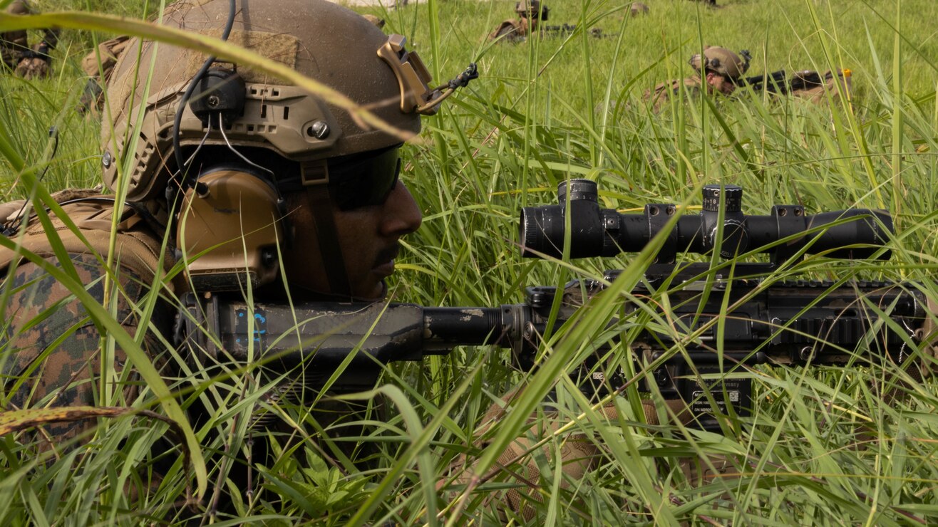 U.S. Marine Corps Lance Cpl. Cristobal Denaoseguera, an infantry Marine with Battalion Landing Team 2/5, 31st Marine Expeditionary Unit, holds a defensive position during a helicopter raid exercise on Ie Shima, Okinawa, Japan, Aug. 03, 2022. The exercise trained Marines on securing an objective, defending it, and creating a forward arming and refueling point. The 31st MEU is operating aboard ships of the Tripoli Amphibious Ready Group in the 7th Fleet area of operations to enhance interoperability with allies and partners and serve as a ready response force to defend peace and stability in the Indo-Pacific region.