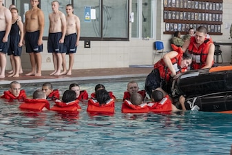 220706-N-ZW825-0779 GREAT LAKES, Ill. (July 6, 2022) Naval Reserve Officers Training Corps (NROTC) New Student Indoctrination (NSI) midshipman candidates board a life raft during a survival at sea training event at Recruit Training Command (RTC), July 6. Upon completion of NSI, the candidates will start their freshman year of the NROTC program at colleges and universities nationwide this fall. NSI is an indoctrination program hosted at RTC, and provides midshipmen with a common military training orientation. NSI provides basic training in five warfighting fundamentals – firefighting, damage control, seamanship, watchstanding and small arms handling and marksmanship – to begin creating basically trained and smartly disciplined future Navy and Marine Corps officers. NROTC is overseen by Commander, Naval Service Training Command (NSTC), Rear Adm. Jennifer S. Couture, which supports naval accessions training for 98 percent of the Navy’s new officers and enlisted Sailors. (U.S. Navy photo by Chief Mass Communication Specialist Byron C. Linder)